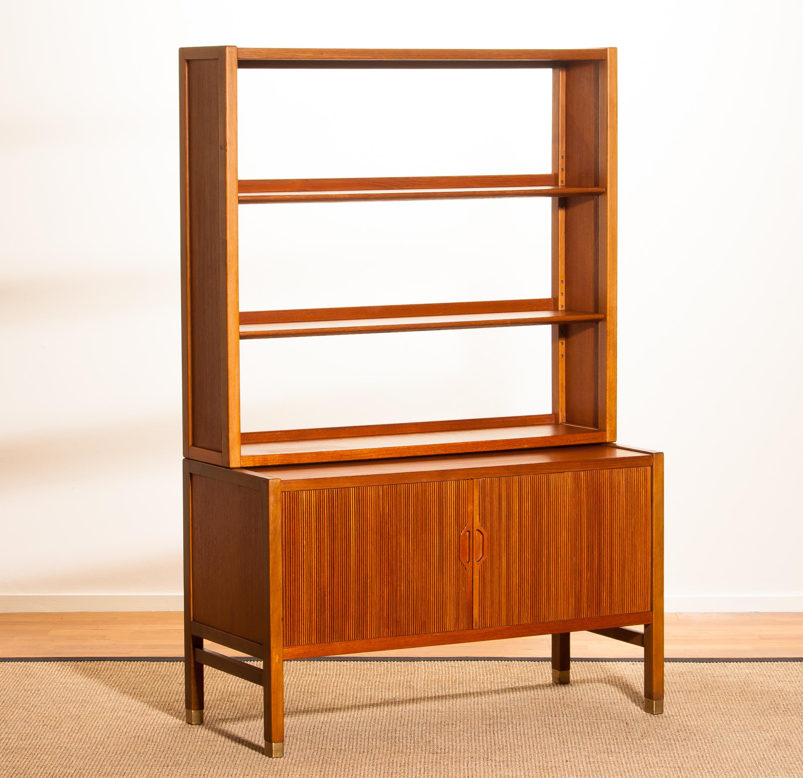 Very beautiful and elegant teak cabinet with tambour doors by Carl-Axel Acking for Bodafors, Sweden.
The lower part of the cabinet has two tambour doors and inside an adjustable shelf. The top part has two adjustable shelves. All in perfect