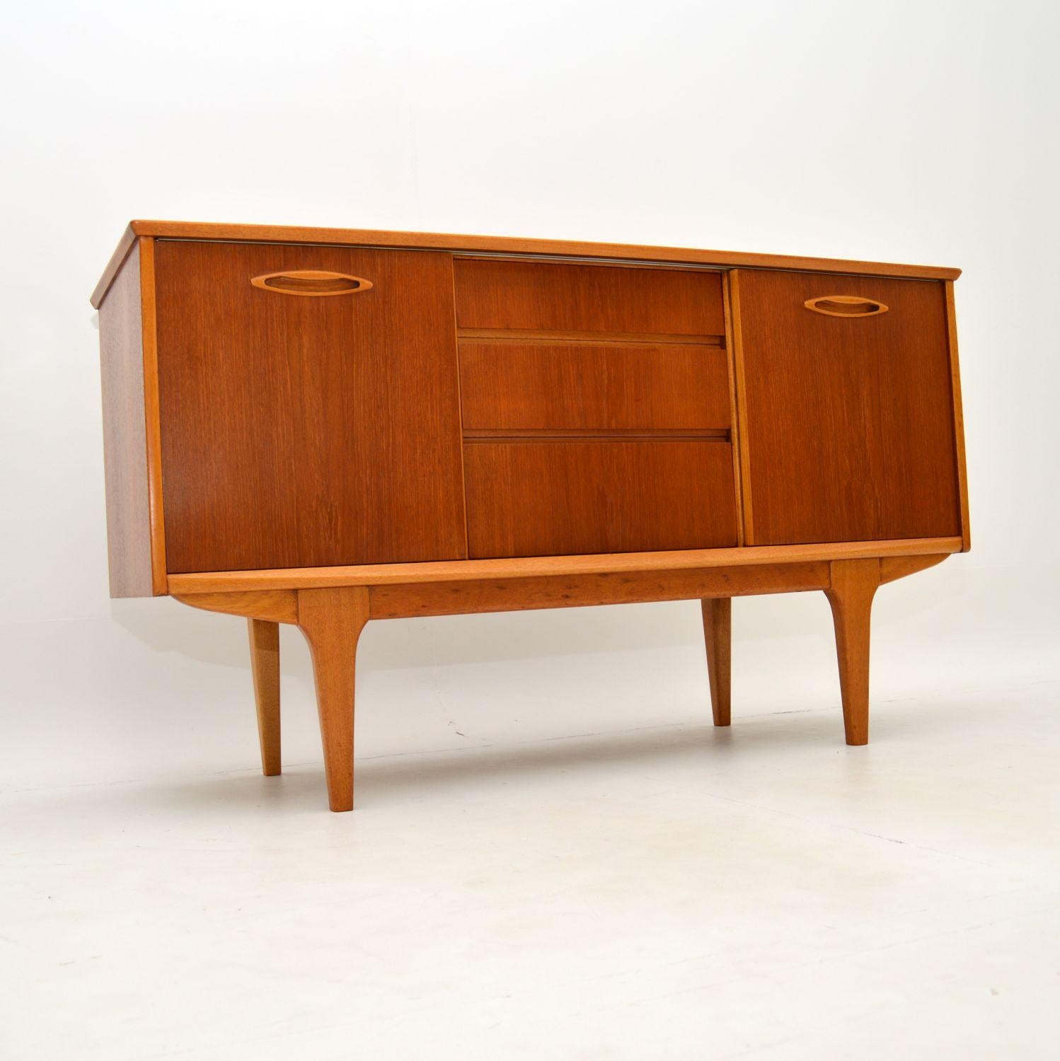A wonderful vintage sideboard in teak. This was made in England by Jentique, it dates from the 1960’s.

This model is of excellent proportions, it is very compact, yet sleek and elegant. There are two sliding doors with shelves in the cupboards,