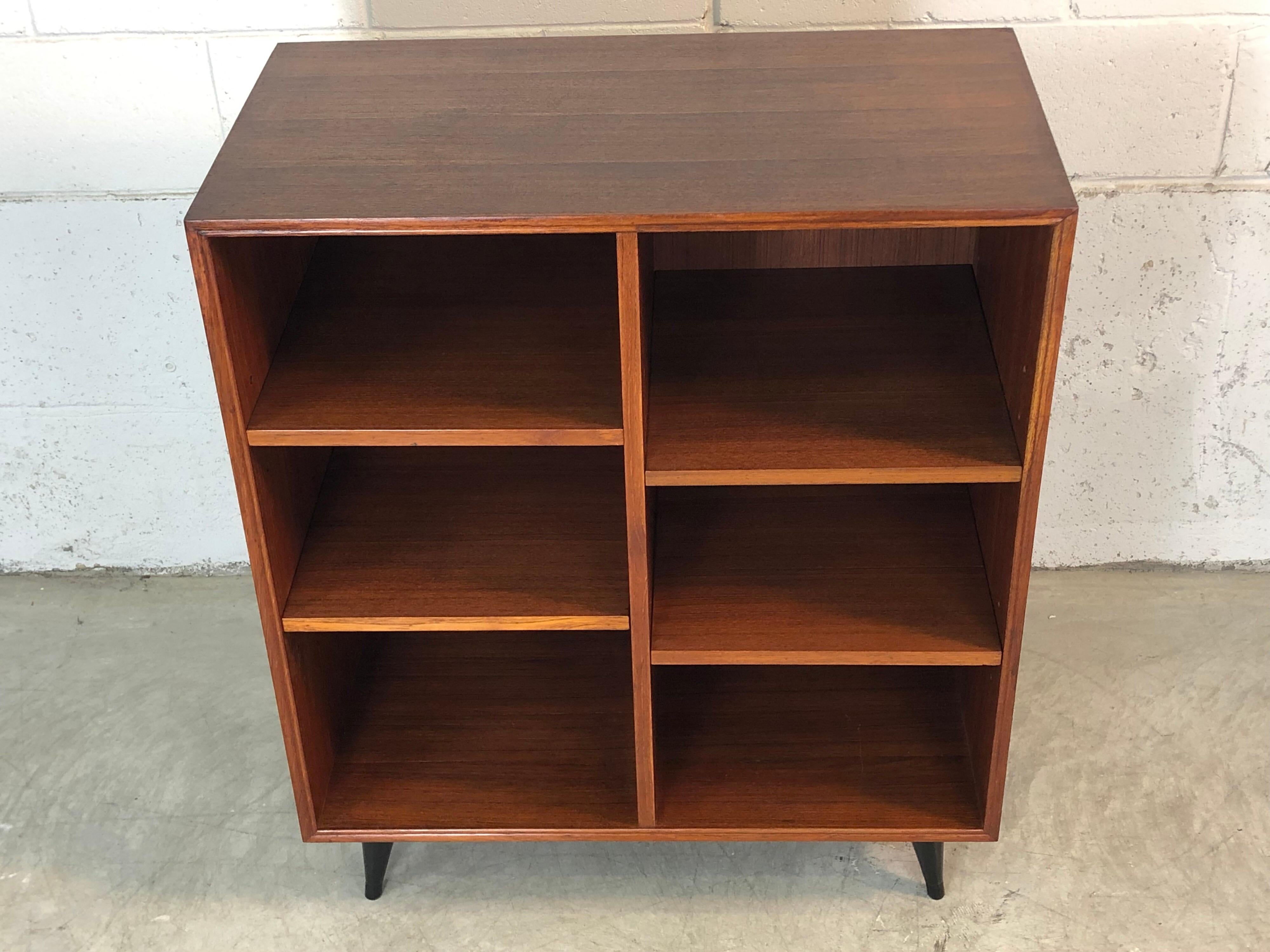 Vintage 1960s teak wood adjustable shelf bookcase. Great compact size and the shelves can be configured any way you want. Legs are painted black. The bookcase has been restored and refinished and is in excellent condition.