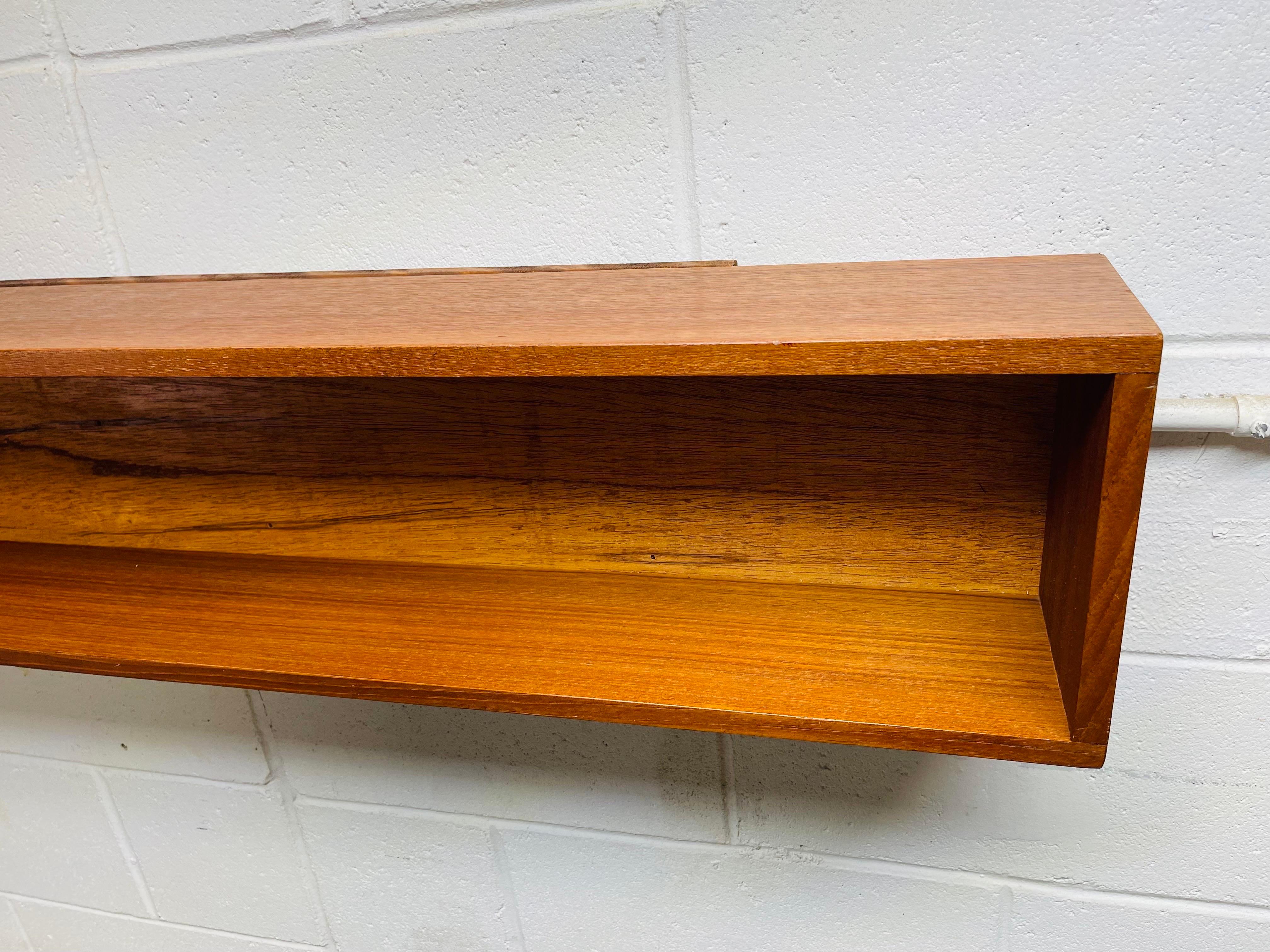 Vintage 1960s teak wood large floating wall shelf. No marks. Mounting hardware provided. Interior measures 5.25”D x 7.25”H.