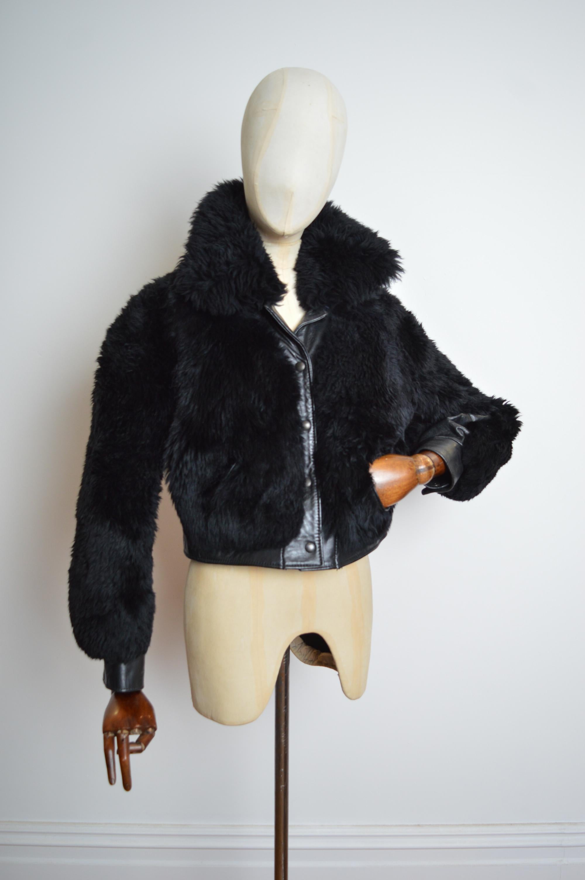 Exclusivo abrigo bomber de piel de oveja negra gruesa de los años 60, confeccionado con piel negra lisa y piel de oveja negra suave y esponjosa, de manga larga, bolsillos en la cadera y cierre con botones a presión en la parte delantera. 
Talla; se