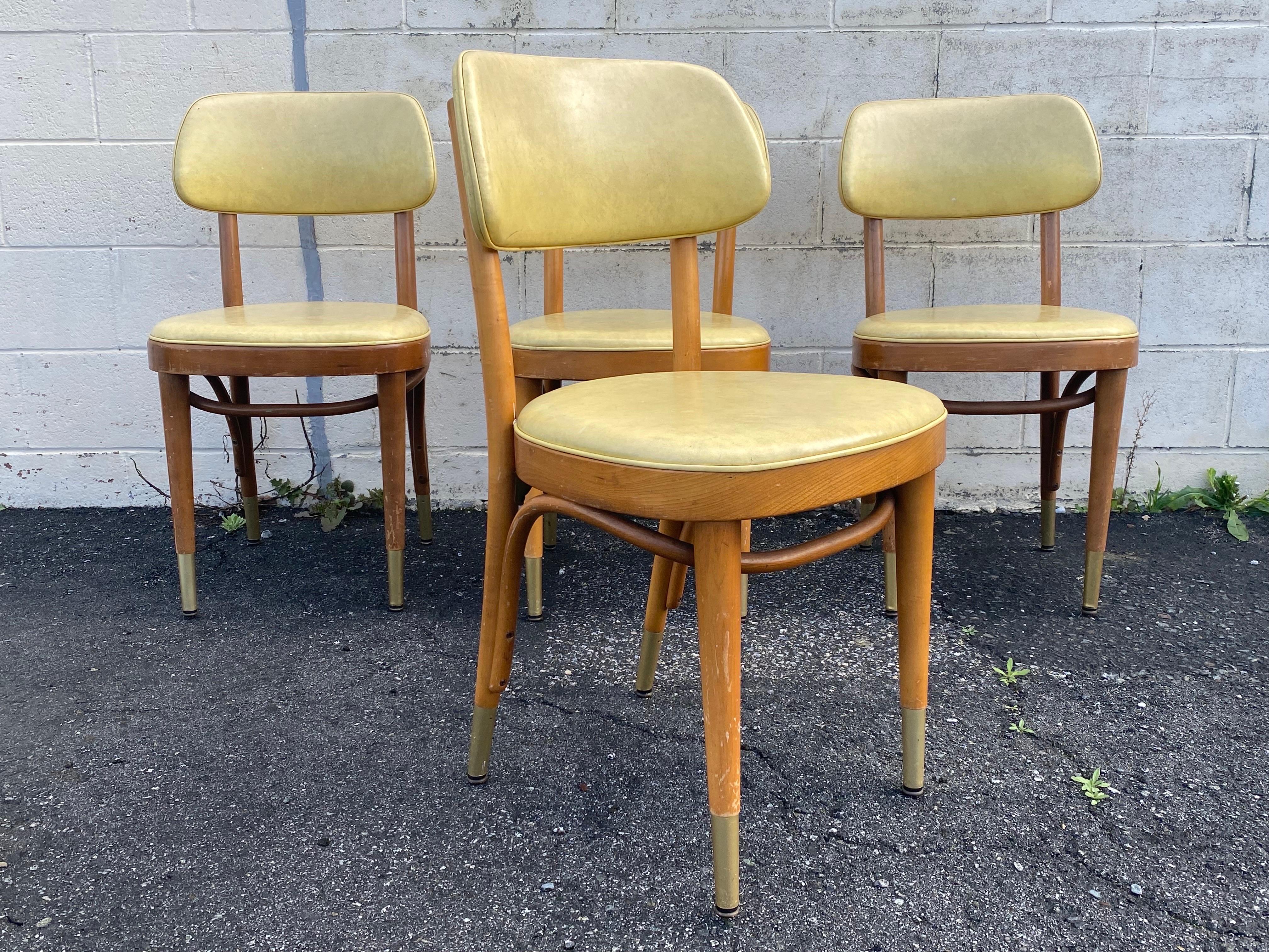 Very cool set of Mid-Century Modern bentwood chairs made by Thonet. These chairs come with its original yellow vinyl upholstery and brass accent feet. An excellent modern timepiece, don't miss out !