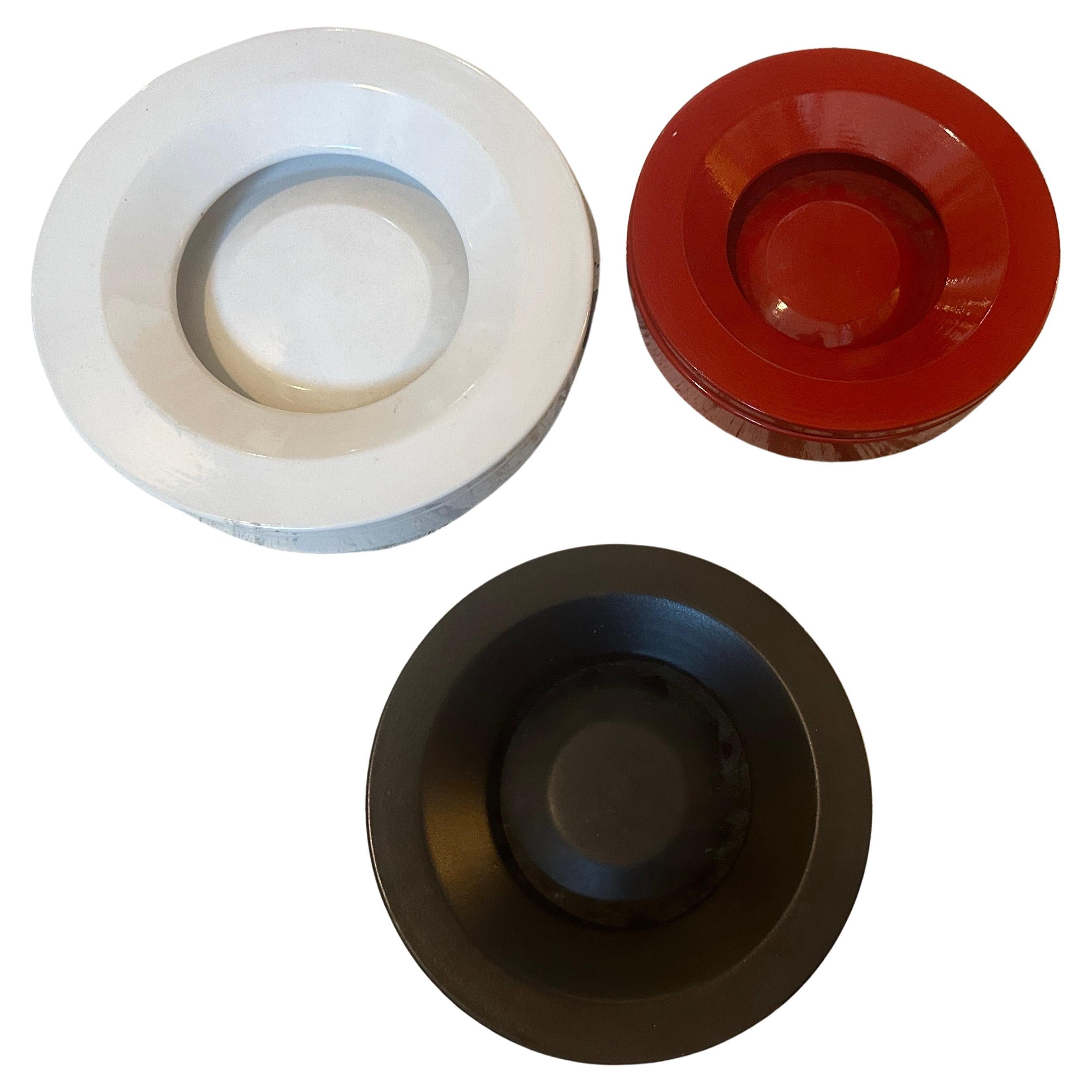 Three vintage ceramic ashtray designed by Angelo Mangiarotti and manufactured by Danese Milano in The Sixties. The three iconic ashtray have different colors, diameter of the white one is 25 cm, the red and the black one diameter id 20 cm. They are