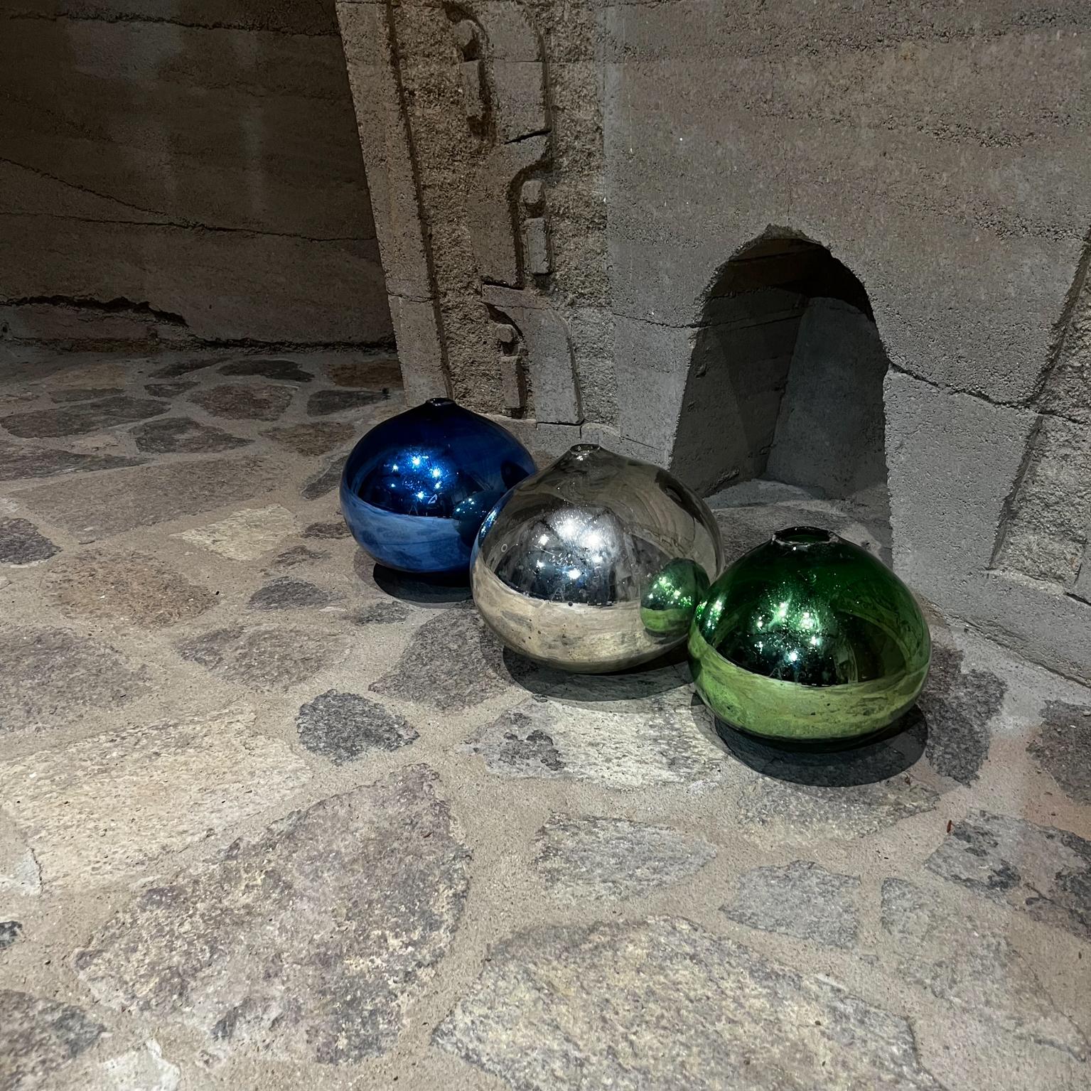 1960s Mexico three colorful globes gazing ball spheres hand blown mercury glass.
Measures: Green 8 tall x 8 diameter silver 10 tall x 10 diameter blue 9 tall x 9 diameter.
Set of 3 mercury colored glass spheres. Crafted in hand blown glass.
No