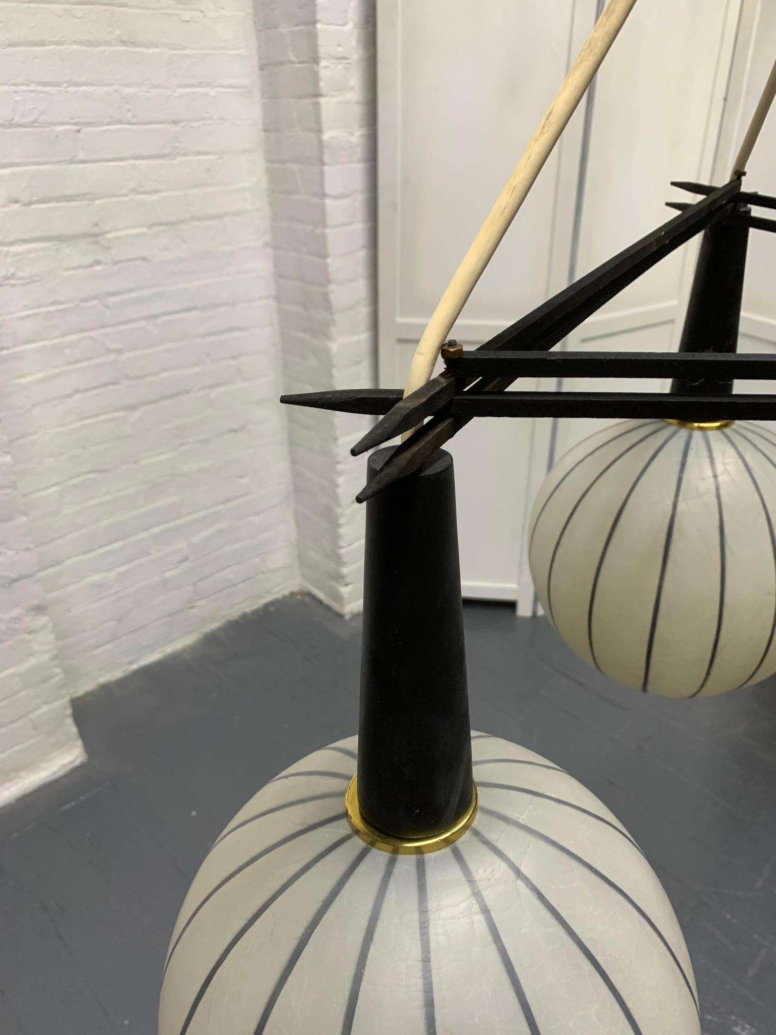 1960s three-globe pendant light fixture. Three large glass globes with a striped pattern supported by a wood stem and a triangular wood rod. 

Measures: Overall 29.25 height x 25.5 in diameter. Each globe: 9.5 in diameter x 9 height.