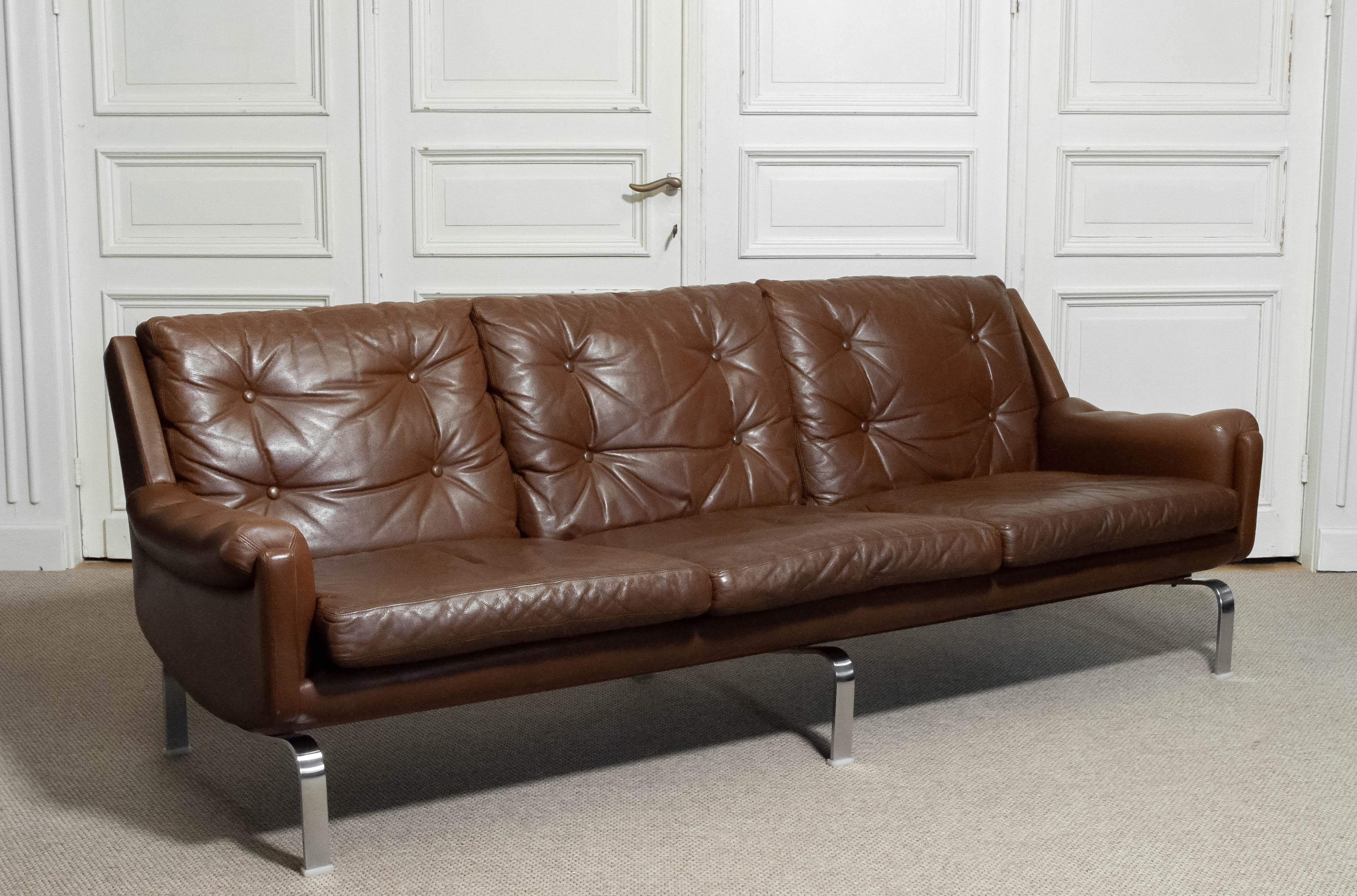 A striking 1960s three-seater sofa in rich brown leather, produced by OPE Möbler, Sweden. This elegant piece exemplifies Scandinavian modern design, where refined craftsmanship meets understated luxury.
The sofa features deeply tufted back cushions