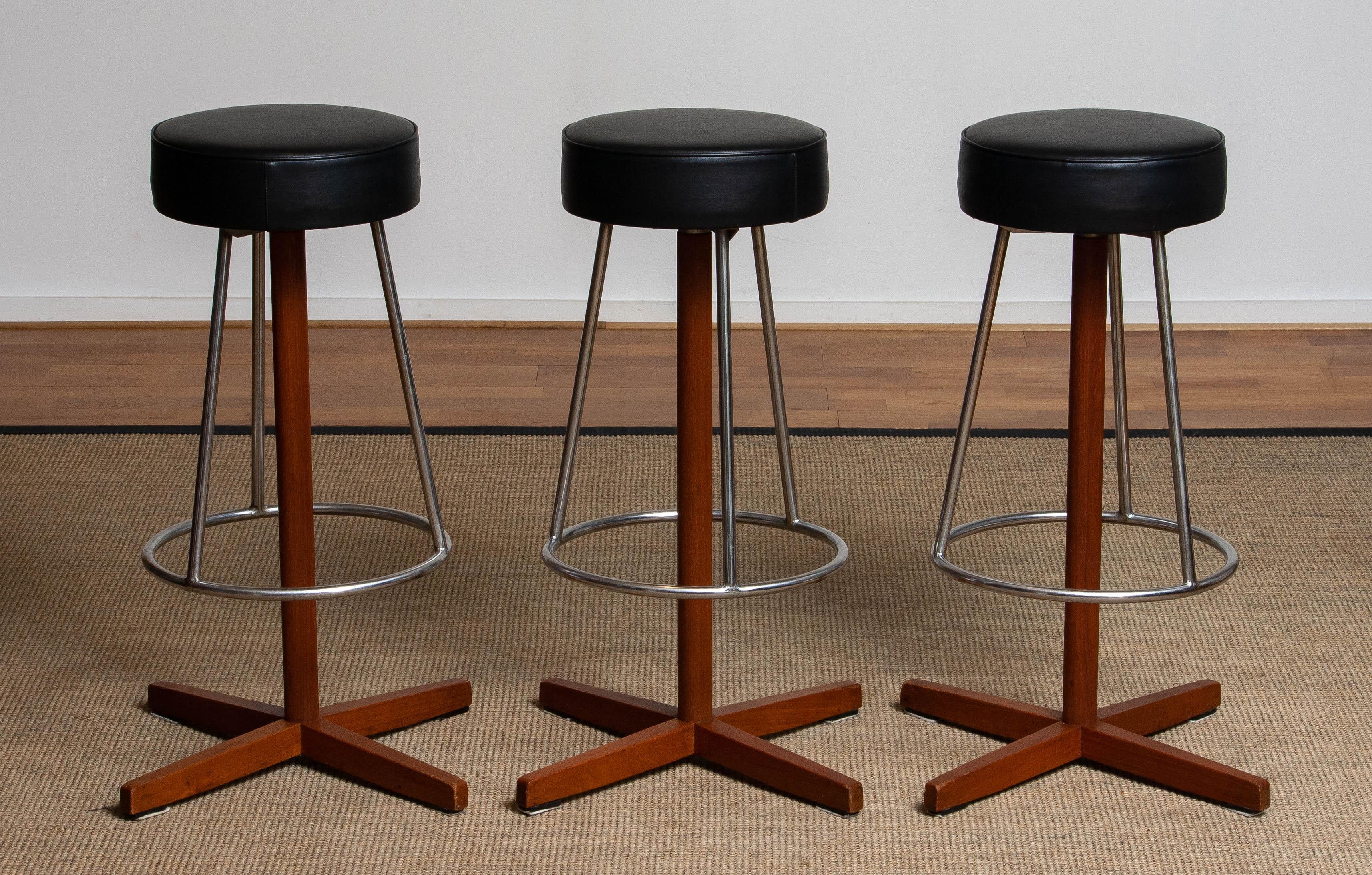 Very beautiful set of three slim teak swivel bar stools by Börje Johanson for Johanson Design Sweden in allover very good condition. All three are upholstered with black faux leather.

Please note!
Because Shipping Costs highly fluctuate daily, we
