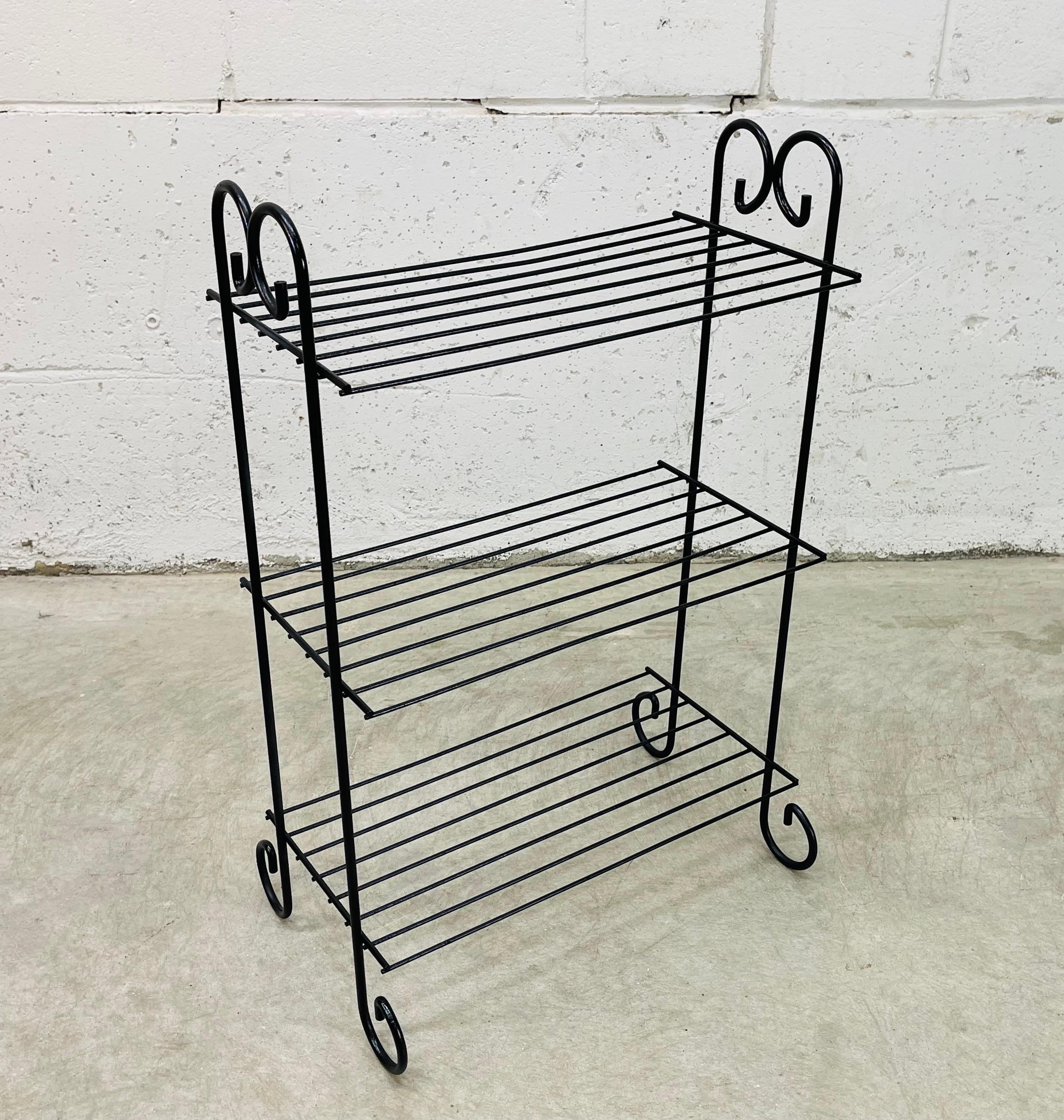 Vintage 1960s metal three tier black shelf. The shelf has turned rounded edges. The shelves are 9.5” apart. No marks.