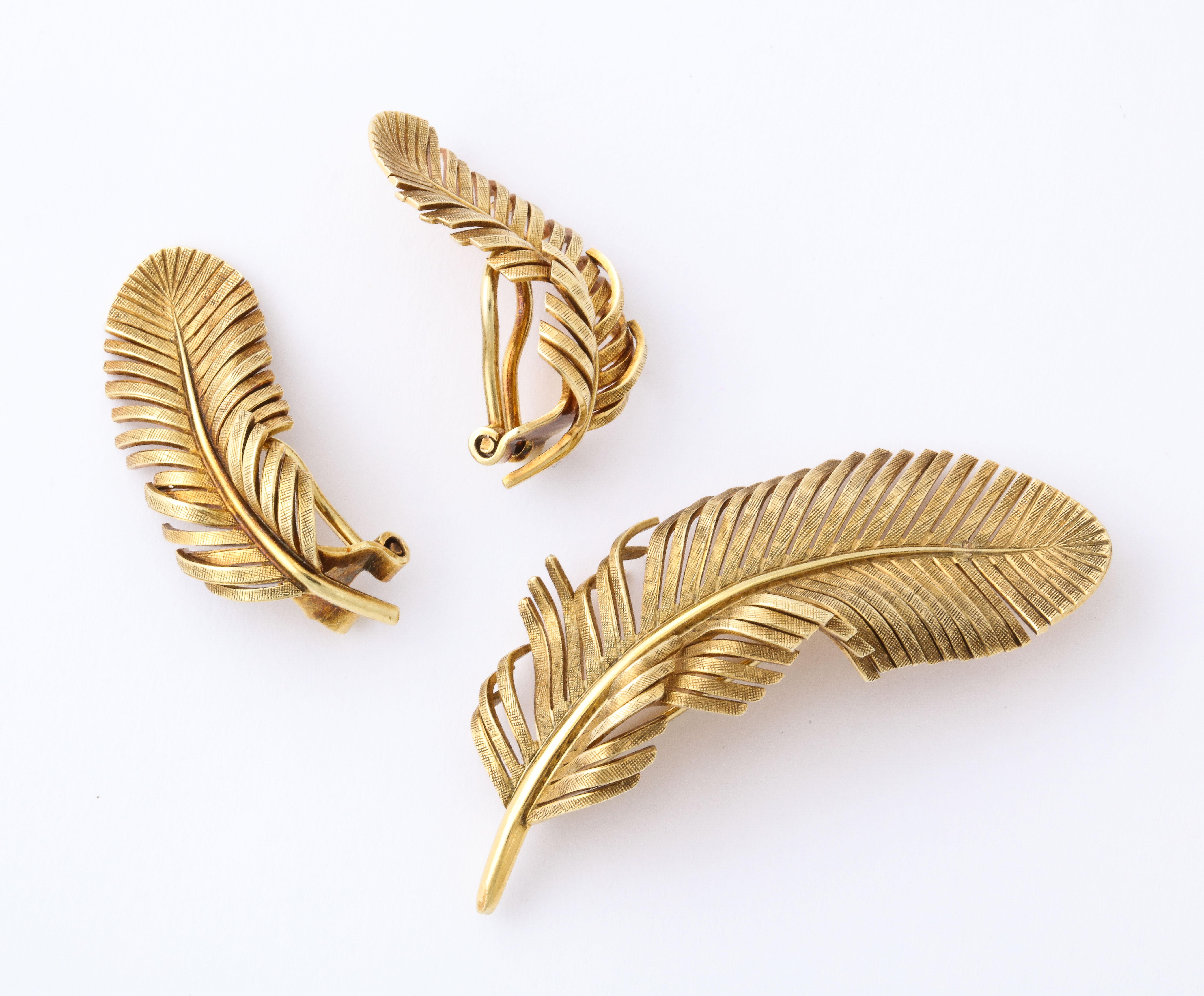 Vintage 1960s Tiffany Co. - Germany hand crafted ear clips and brooch as fancy feathers of 14K gold. Brooch measures 3/4 inch x 2 inches; ear clips 1/2 inch x 1 1/4 inches. Total weight 15.70 grams. Gold mark and Tiffany Co. - Germany.