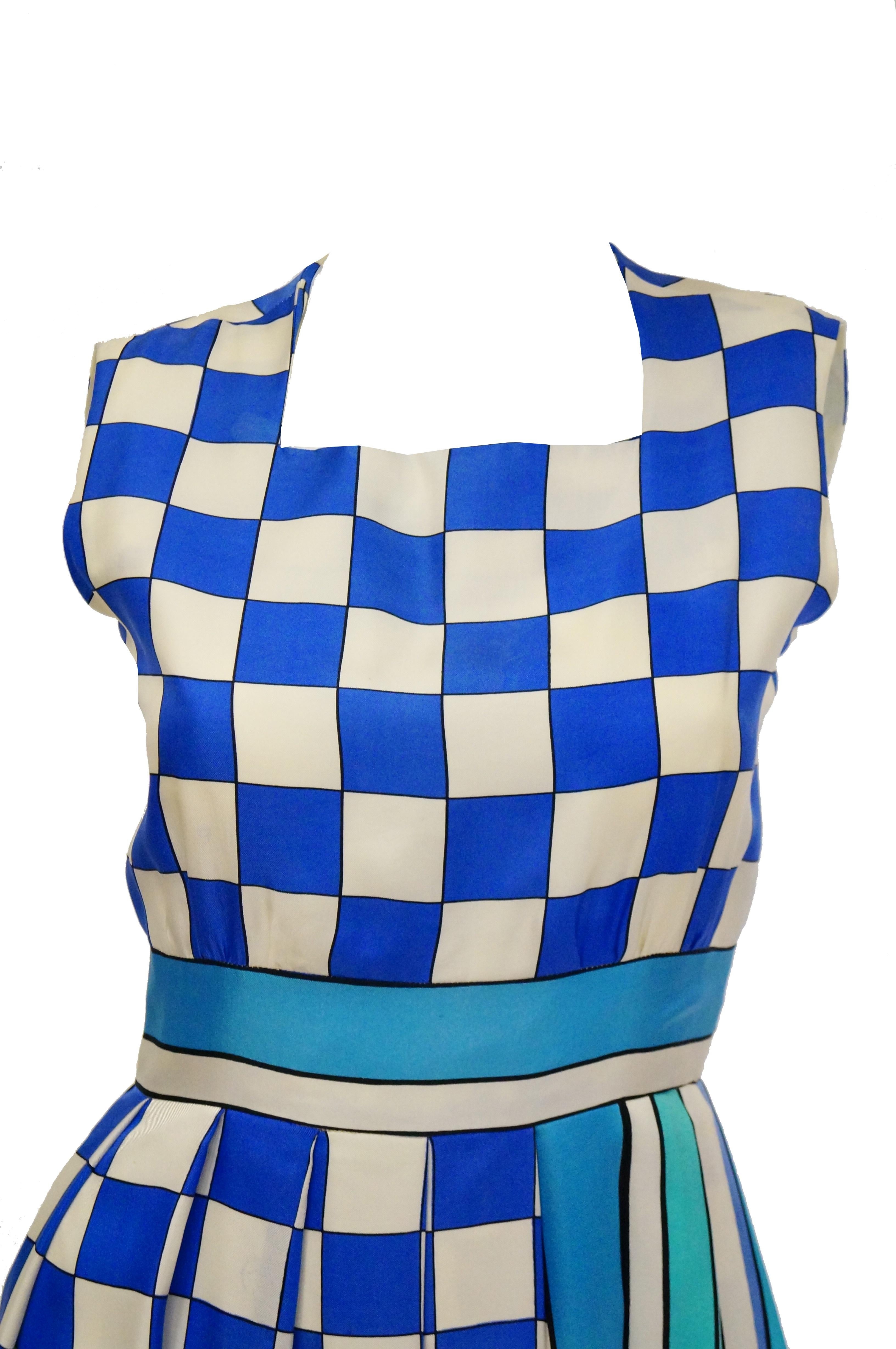 Fabulously fresh blue and white maxi dress by Tina Leser. The dress has a classic A - line silhouette, with wide skirt, no sleeves, and square neckline. The dress primarily features a checkerboard print in royal blue and white, accented by stripes