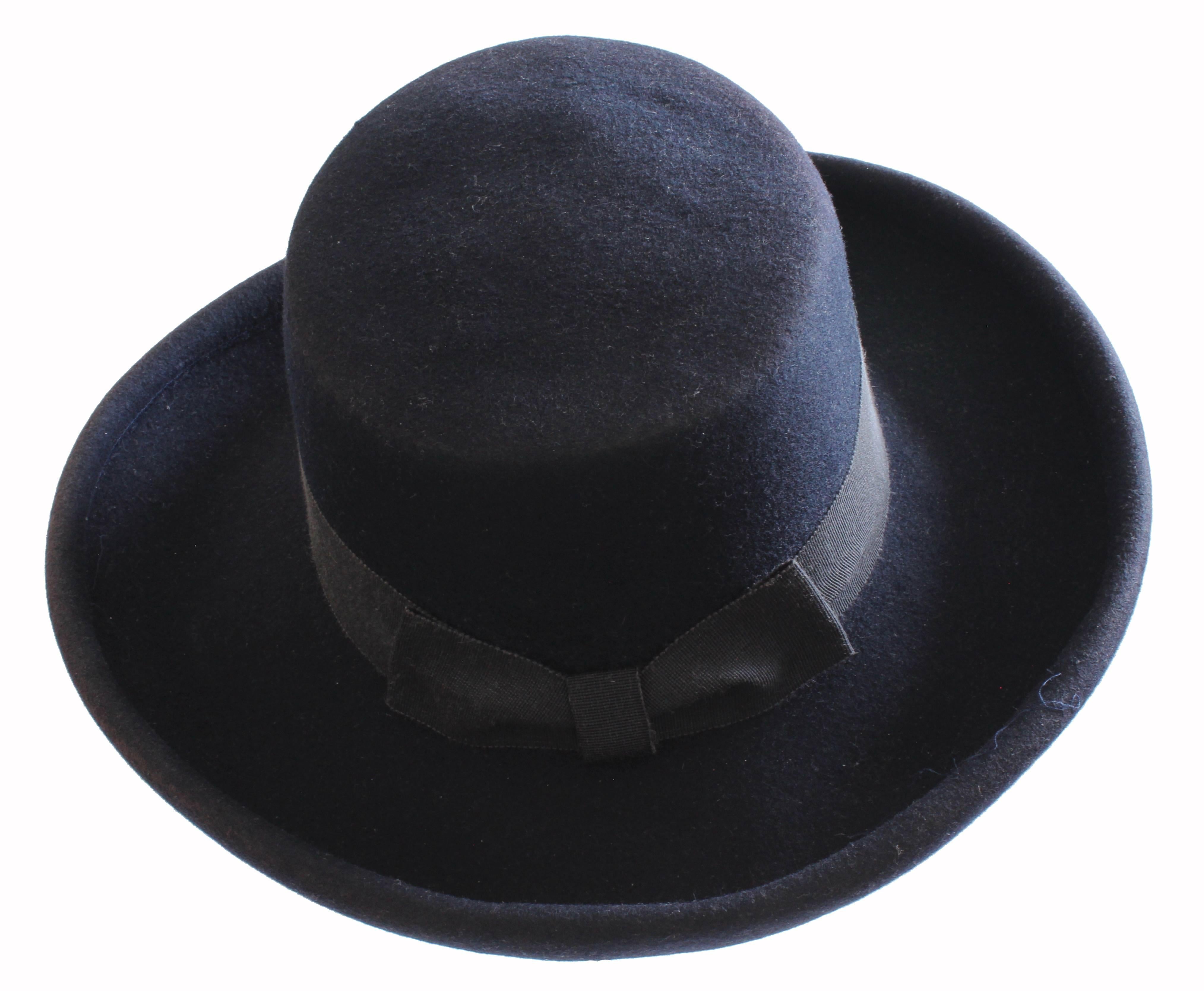 This wide brim hat was made by Tina Too and the Bollman Hat Company, most likely in the 1960s.  Made from navy blue wool Doeskin felt, it features a grosgrain band at the crown.  In good condition given its age, we note slight fading to the edges. 