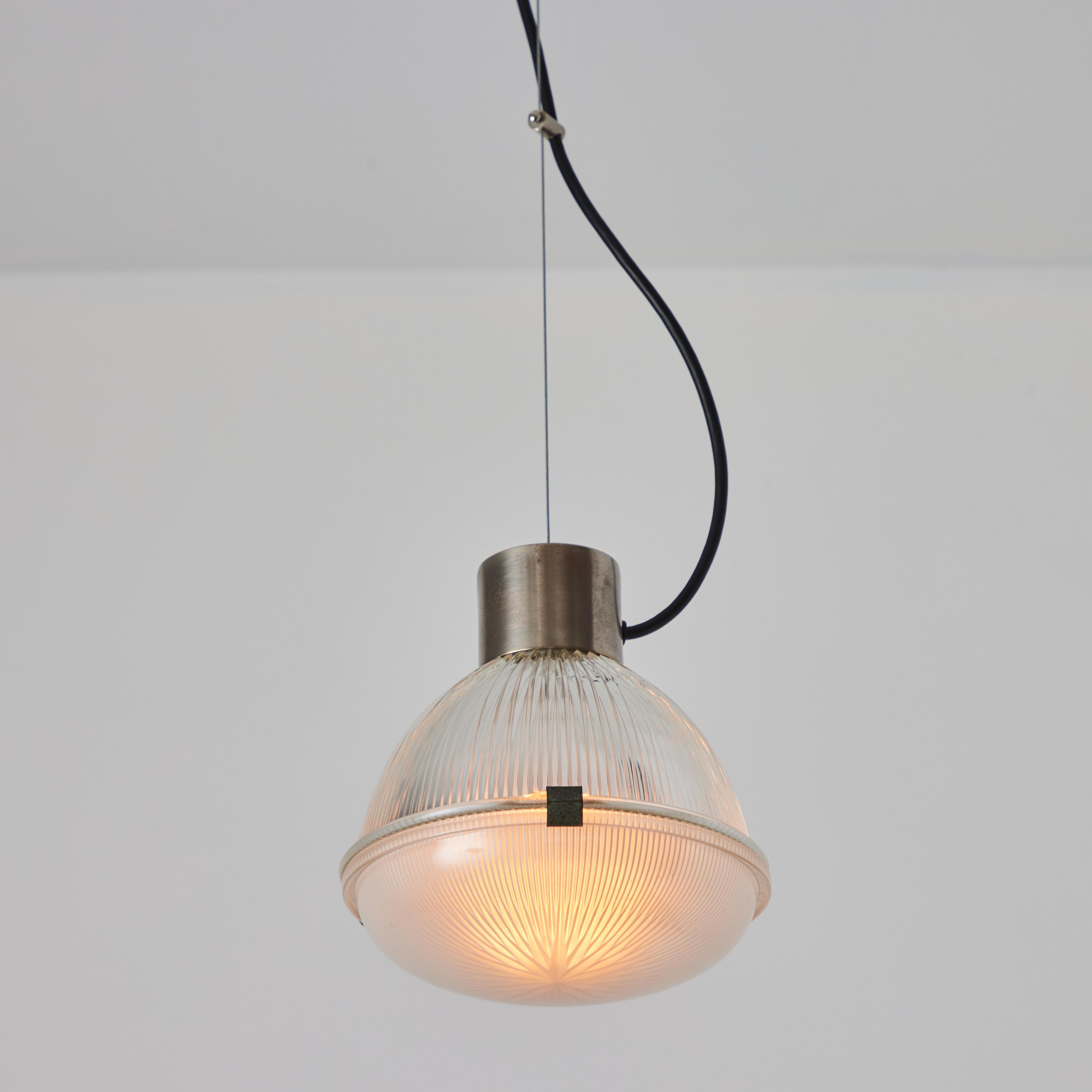 Lampada a sospensione anni '60 di Tito Agnoli modello #4409 per O-Luce. Questi iconici pendenti sono realizzati in metallo con due elementi in vetro pressato ingegnosamente tenuti insieme da clip scultoree in acciaio curvato. Un design
