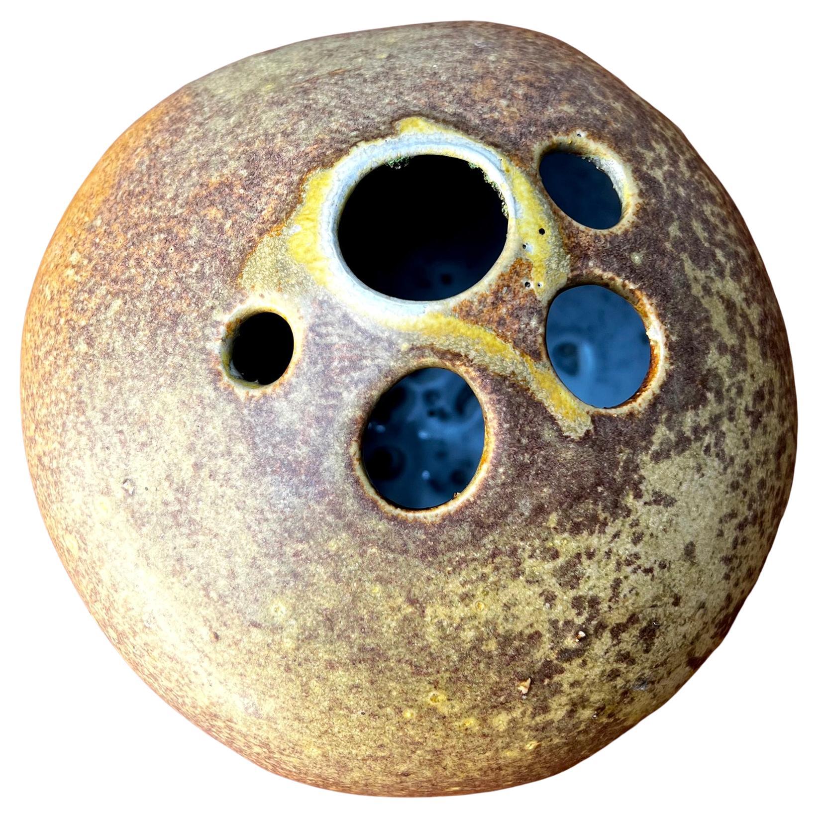 Jarrón de piedra de canto rodado de gres de California Studio Pottery con tres pies creado por Tom McMillin.  La pieza mide 7,25