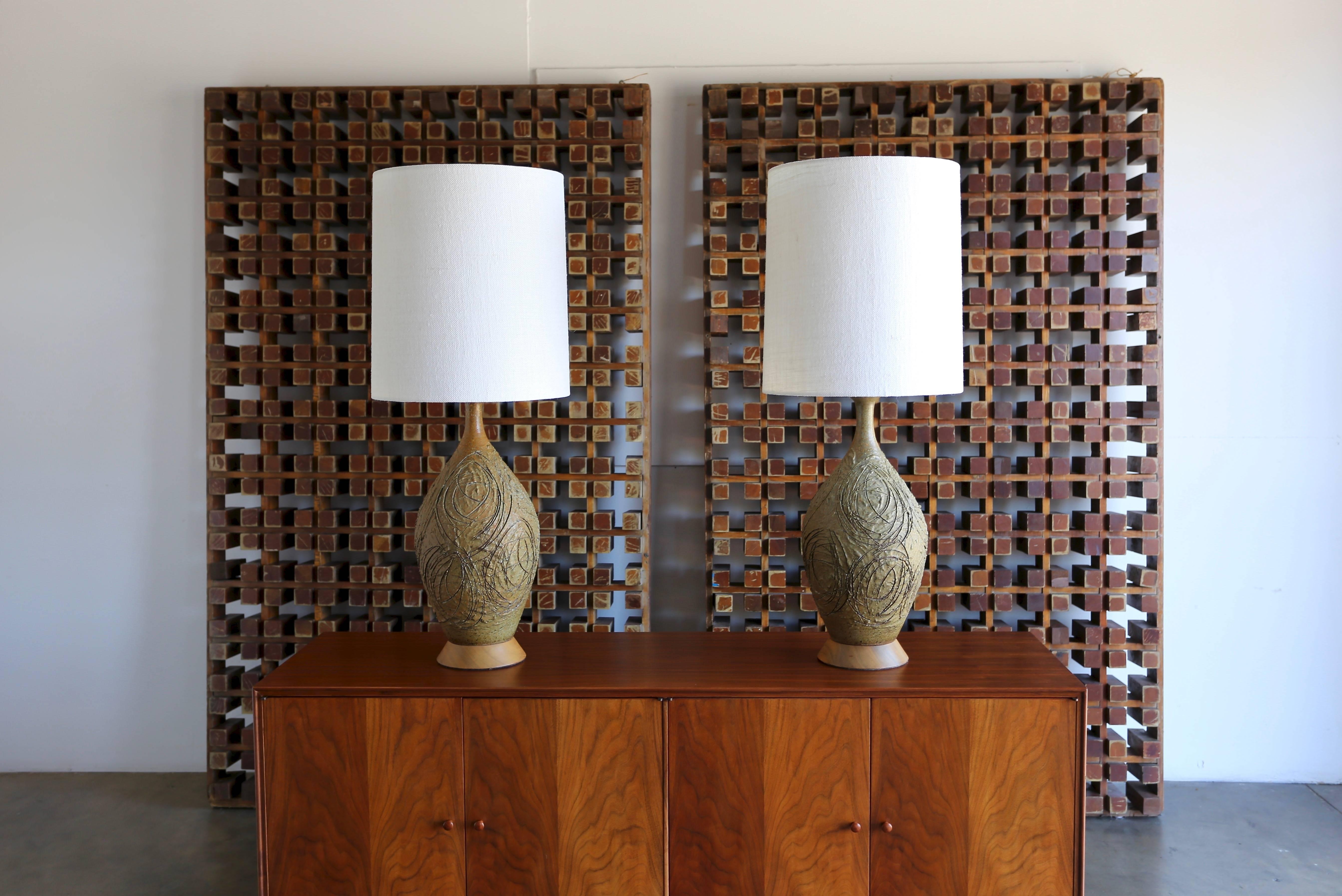 1960s Tom McMillin pair of ceramic table lamps. This pair has been professionally rewired and fitted with new custom shades. The listed measurements include the shades. 

McMillin received an MFA in Ceramics at USC. His work was part of the