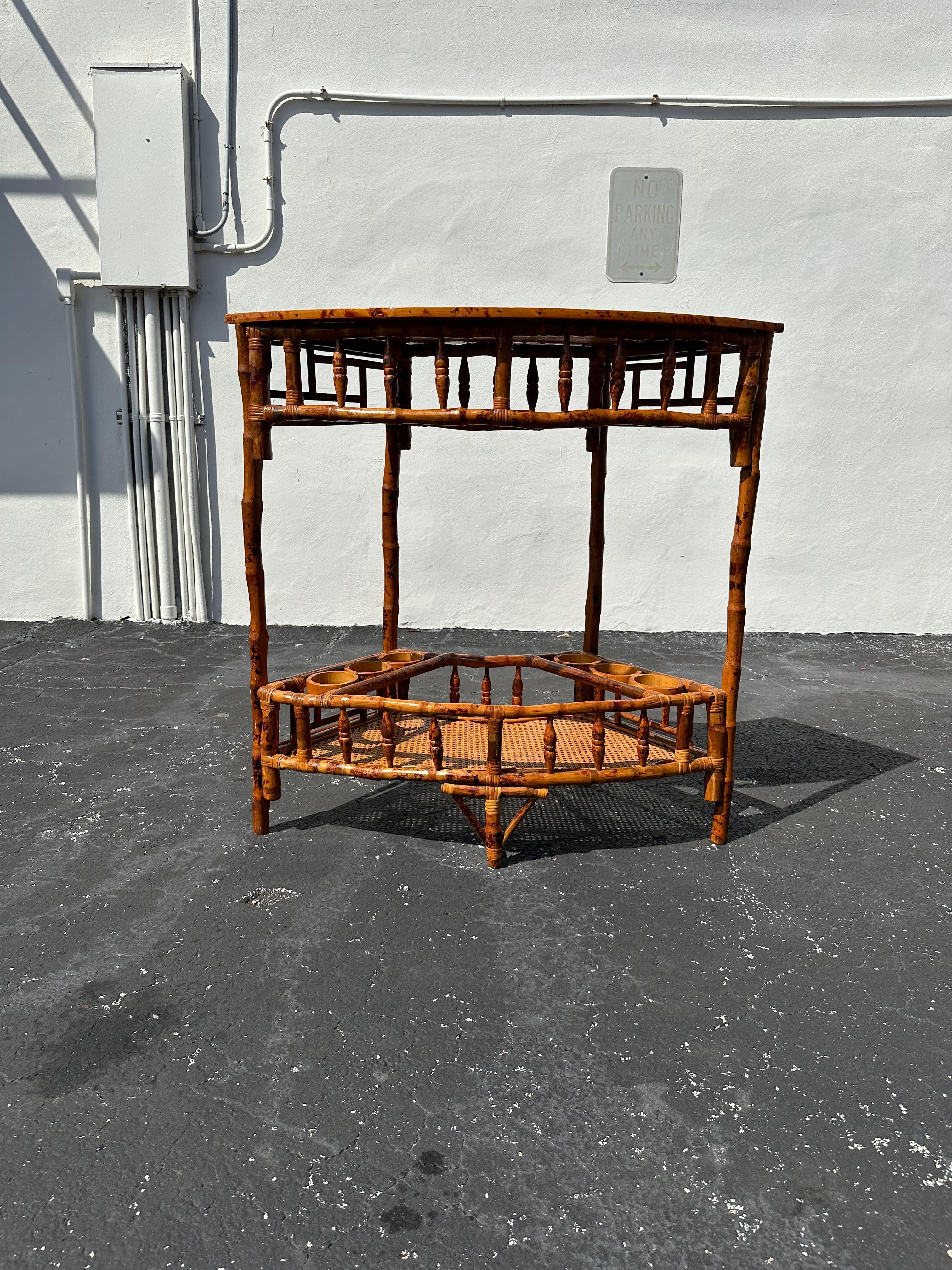 Nous vous proposons ici l'une des plus belles et des plus rares tables de bar à deux niveaux en rotin et en canne que vous puissiez espérer trouver. En état d'origine et inachevé. Le design est remarquable partout. Cette magnifique table est une