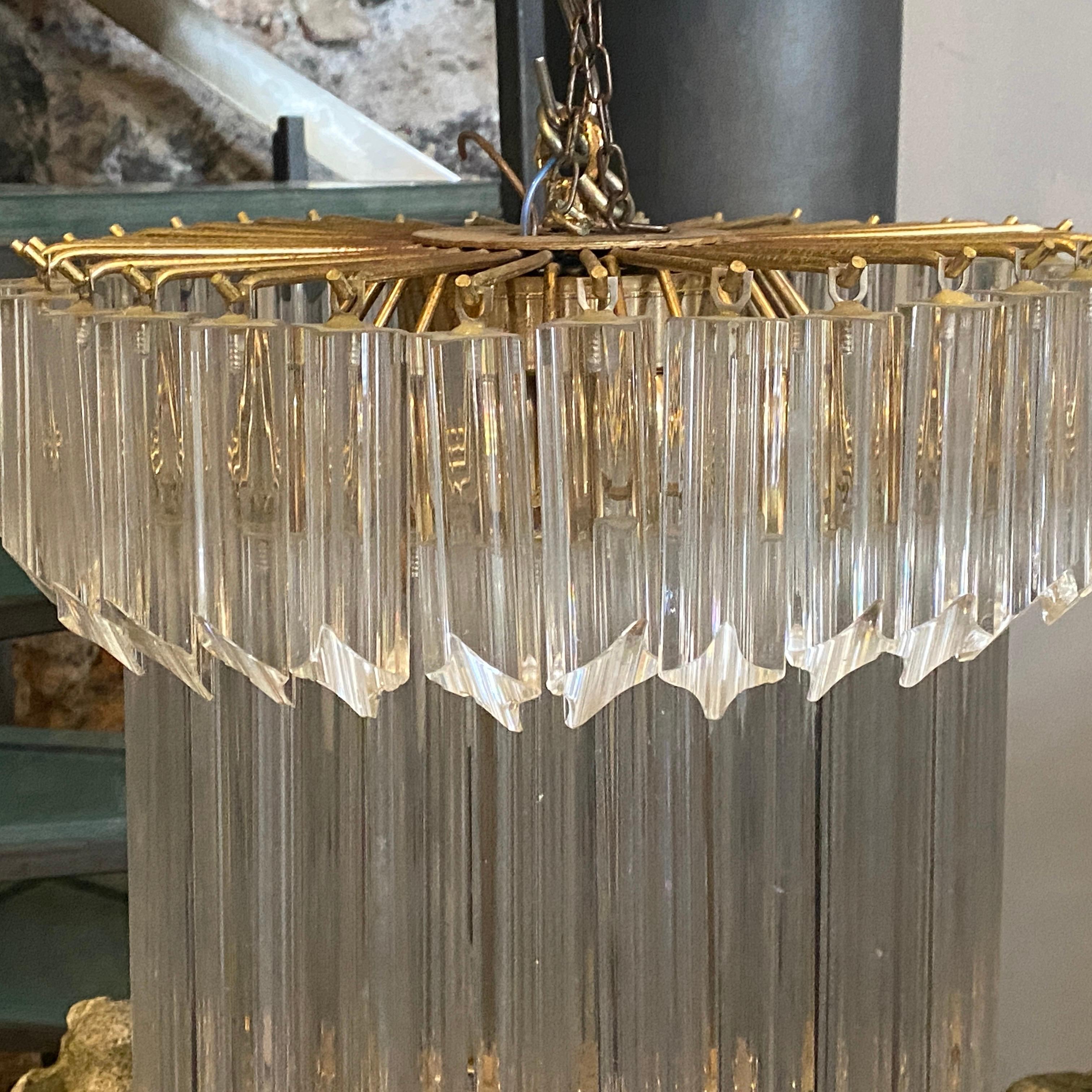 This chandelier is made up of an elegant solid glass prisms mounted on a brass base. Each murano glass, giving you a soft warm light. We should note that any amount of chain can be added to customize the length of the chandelier. It's made by Venini