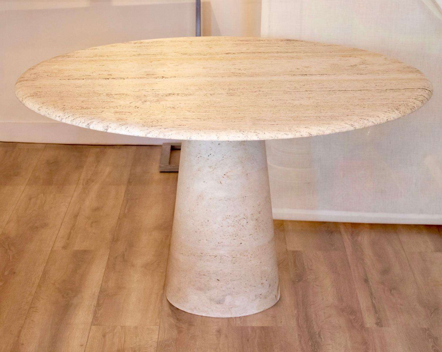Elegant dining table made of polished travertine marble.
Round plate, 49.21 inches of diameter, with a conical foot, 28.34 inches of height.
Edited by the French furniture design publisher Roche Bobois in the 1960s.