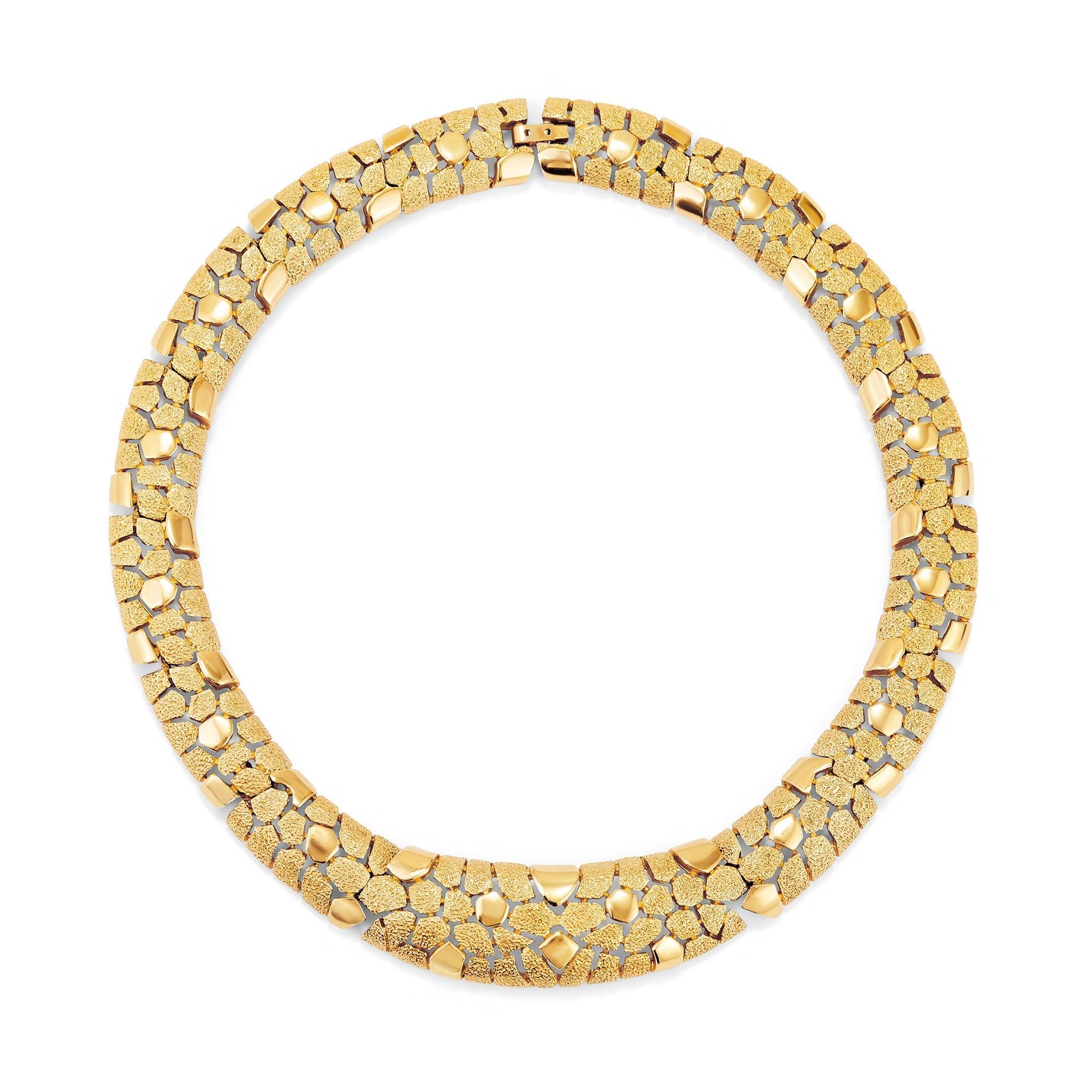 Este collar gargantilla de Trifari fue diseñado en la década de 1960. Formadas por 15 placas interconectadas, están rotas con grietas erráticas y texturizadas para que parezcan casi escamas. El efecto general es el de la piel de un reptil o una