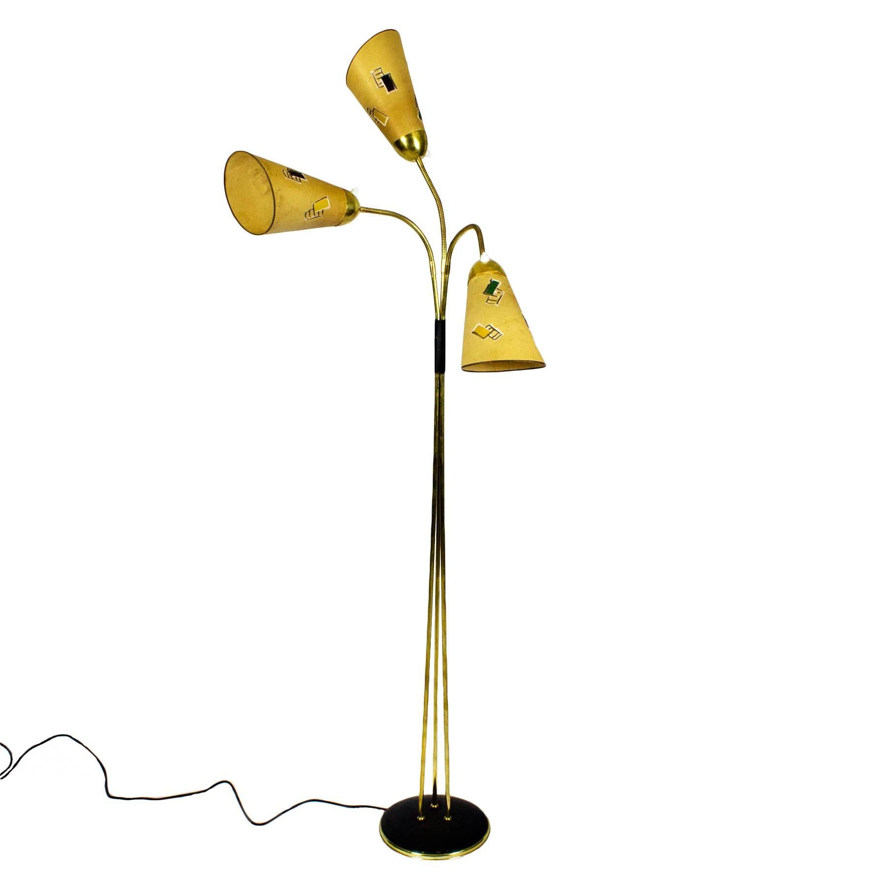 Tripod standing lamp, polished brass, black lacquered steel base, plastified black lace decoration. Three flexible arms with the originals paper (simil parchment) lampshades with relief hand painting patterns (one had been restored. Individual