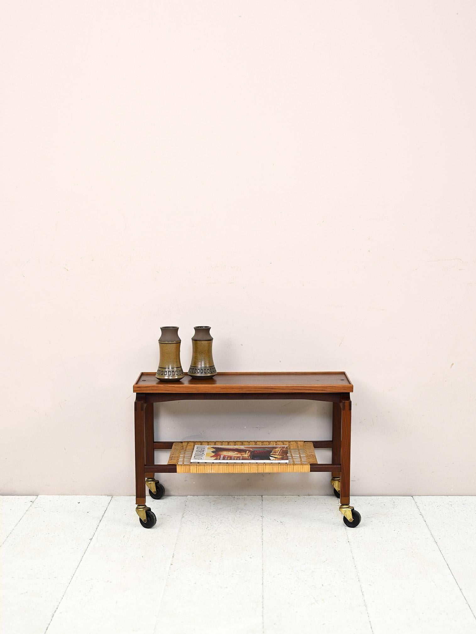 Skandinavischer Vintage Couchtisch mit Rollen.

Dieses stilvolle und funktionelle Möbelstück kann als kleiner Sofatisch oder als Mehrzweckwagen verwendet werden und verfügt über eine Ablage aus geflochtenem Rattan.

Guter Zustand. Es wurde eine