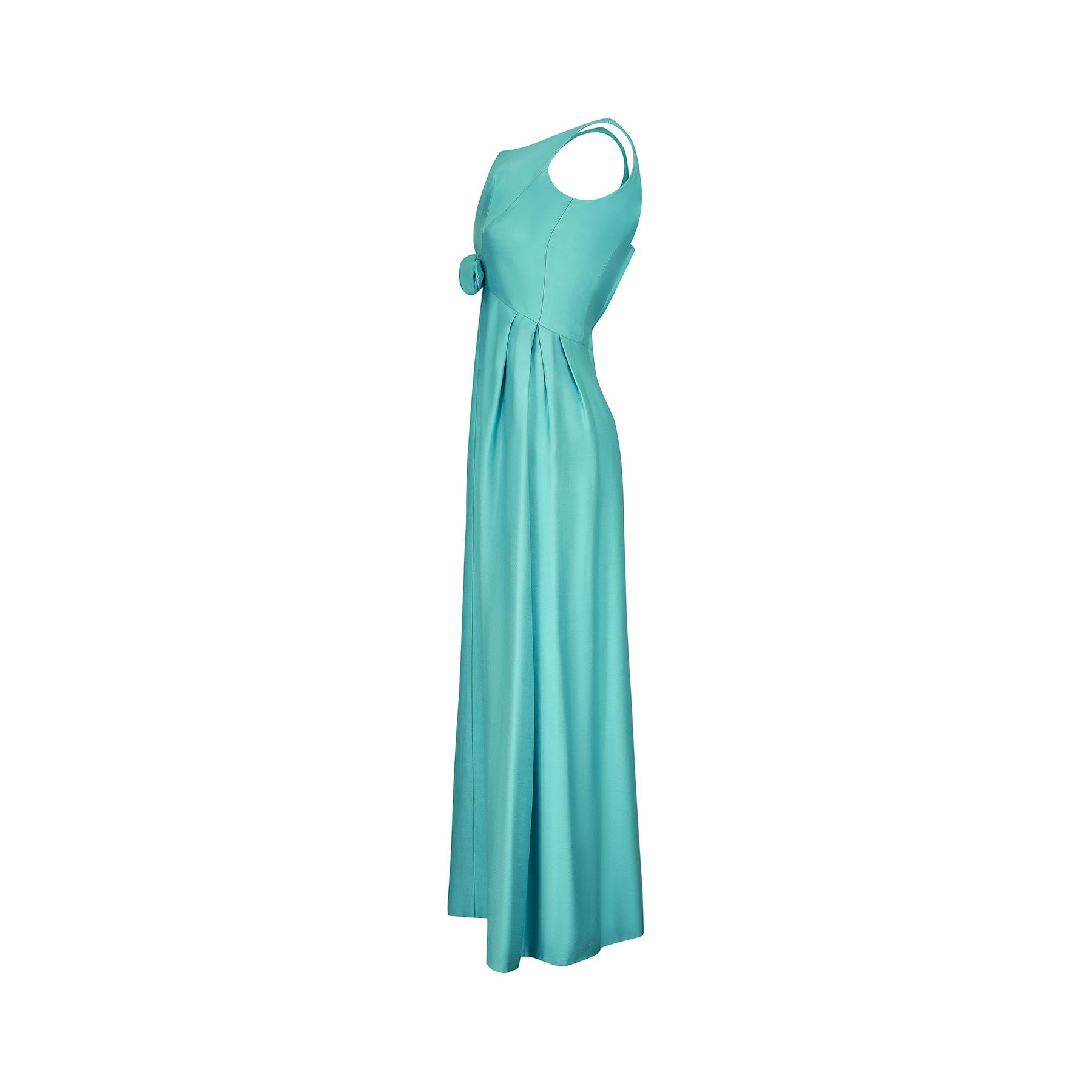 Cette robe longue de la fin des années 1960 au début des années 1970 est taillée dans un mélange de lin et de soie d'un turquoise éclatant et présente une gracieuse silhouette empire. Elle est dotée de larges bretelles et d'un décolleté incurvé,