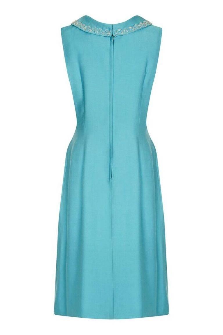 Cette jolie robe Mod en lin des années 1960, bleu turquoise, est élégante et chic. Les lignes simples et les couleurs vives sont habilement réalisées, mais hélas, il n'y a pas d'étiquette du fabricant. Le mini col bénitier est orné de perles fines