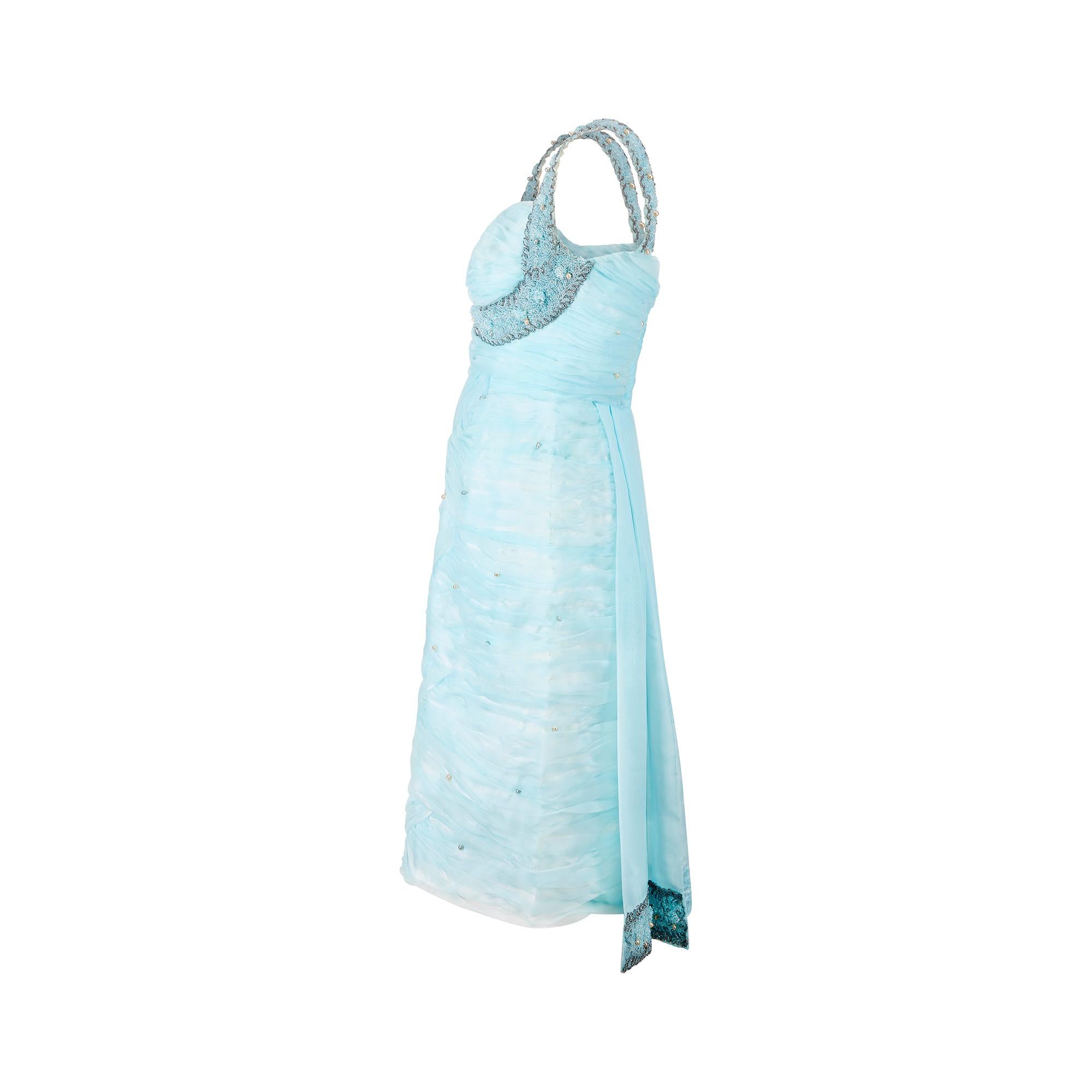This 1960s  cocktail dress is intricately adorned with pale-aqua ruched manmade chiffon stitched in a scalloped pattern across the entire body, the resulting effect is soft and cloud-like; the only distraction the occasional ivory or blue pearl