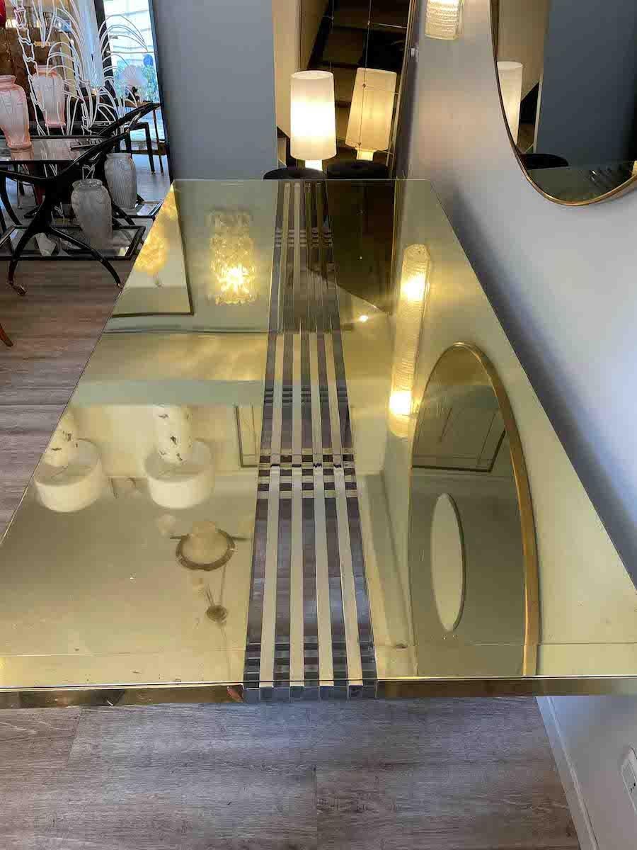 Brass table from the 1960s by Turri Milano. 

The table has a top made of brass and glass on top. The central part of the top is interrupted by brass profiles as long as the table, giving the top more lightness. 

The table legs are made of brass