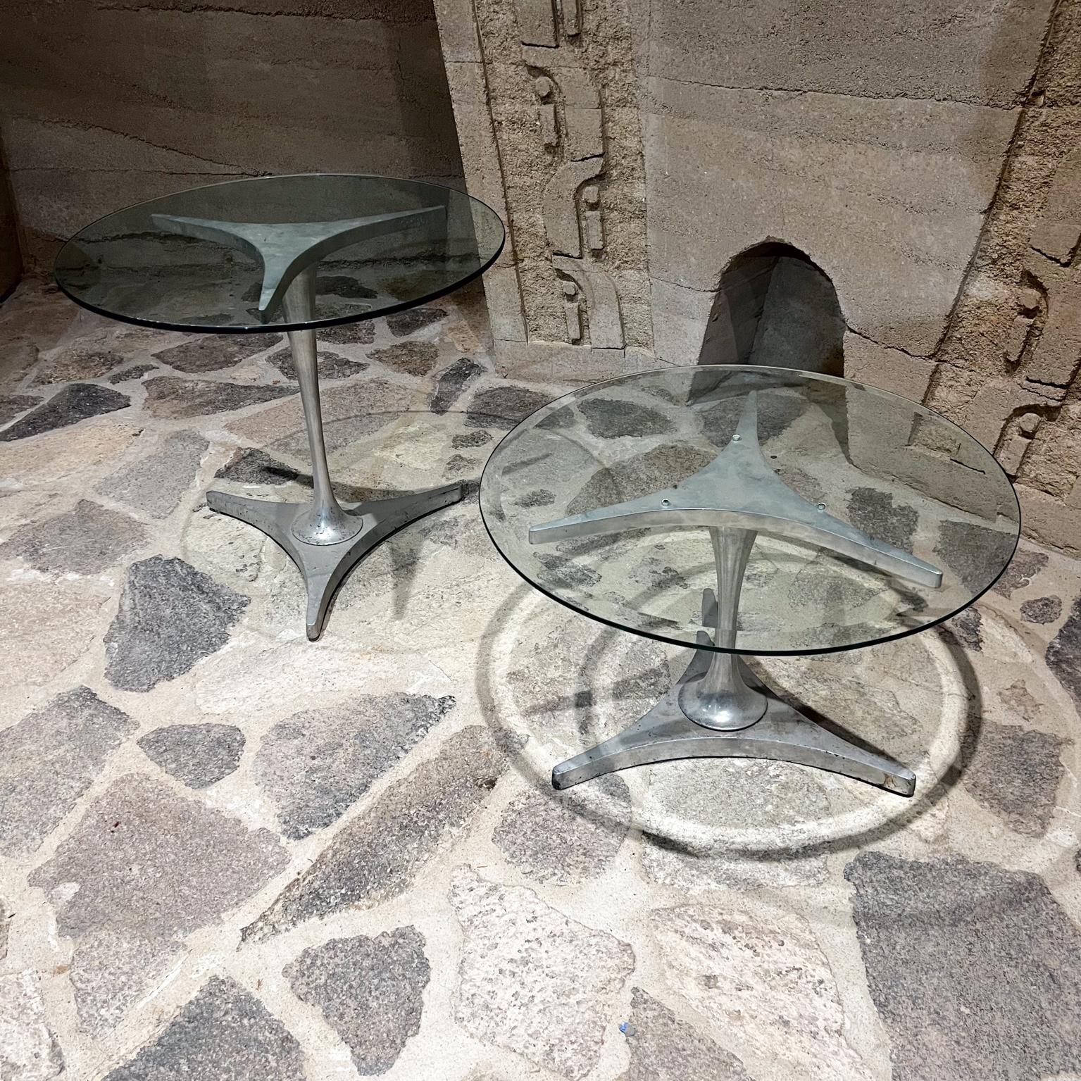 Mid Century Modern Set of Aluminum Nesting Side Tables, set of two. 
Taller 21 x 17 base Smaller 14.5 tall x 17 diameter
Modern tripod base.
Original Unrestored preowned fair condition.
Aluminum with weather exposure shows signs of pitting.
Please