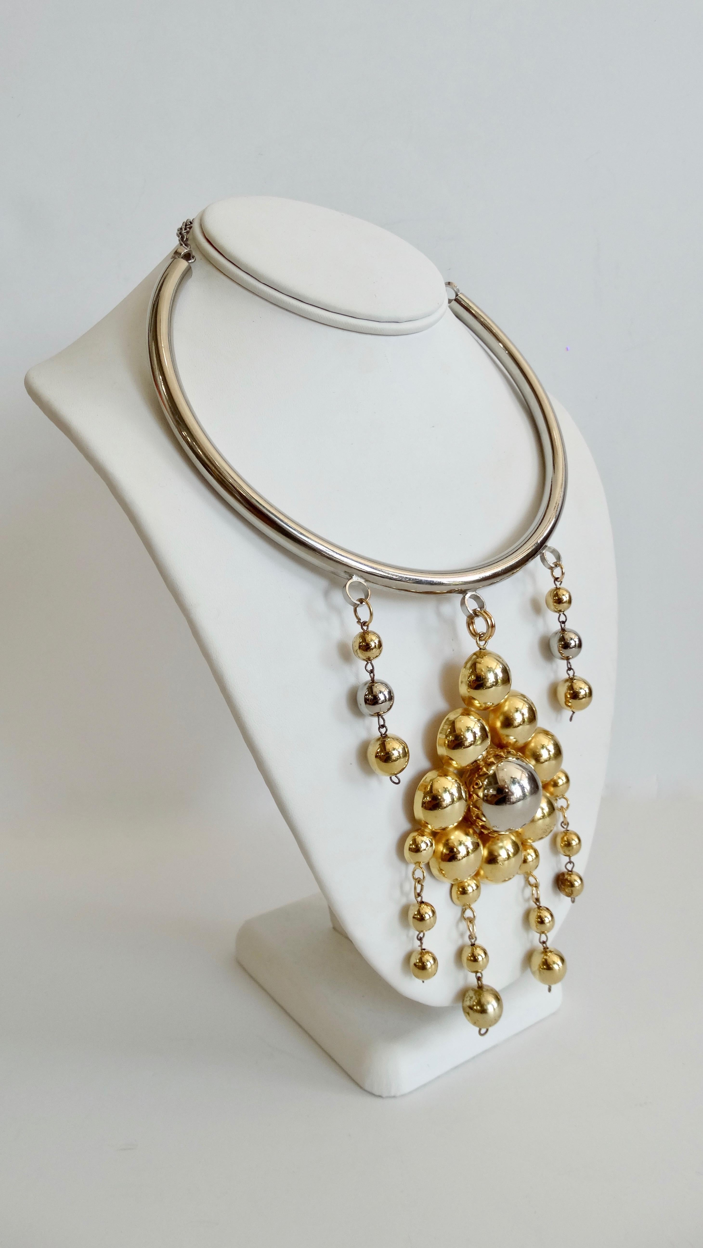 Elevate your outfit with this amazing artisan crafted choker necklace! Think Pierre Cardin Circa 1960s, this mixed metal necklace is plated in silver and gold. Features a thick silver plated band and a series of gorgeous mixed metal beaded pendants.