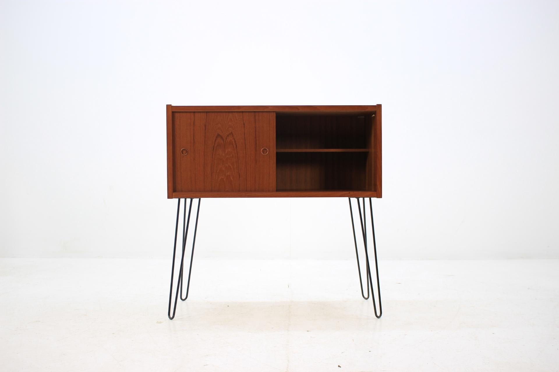 This cabinet features two sliding doors with inner shelve. The iron legs were added afterwards.