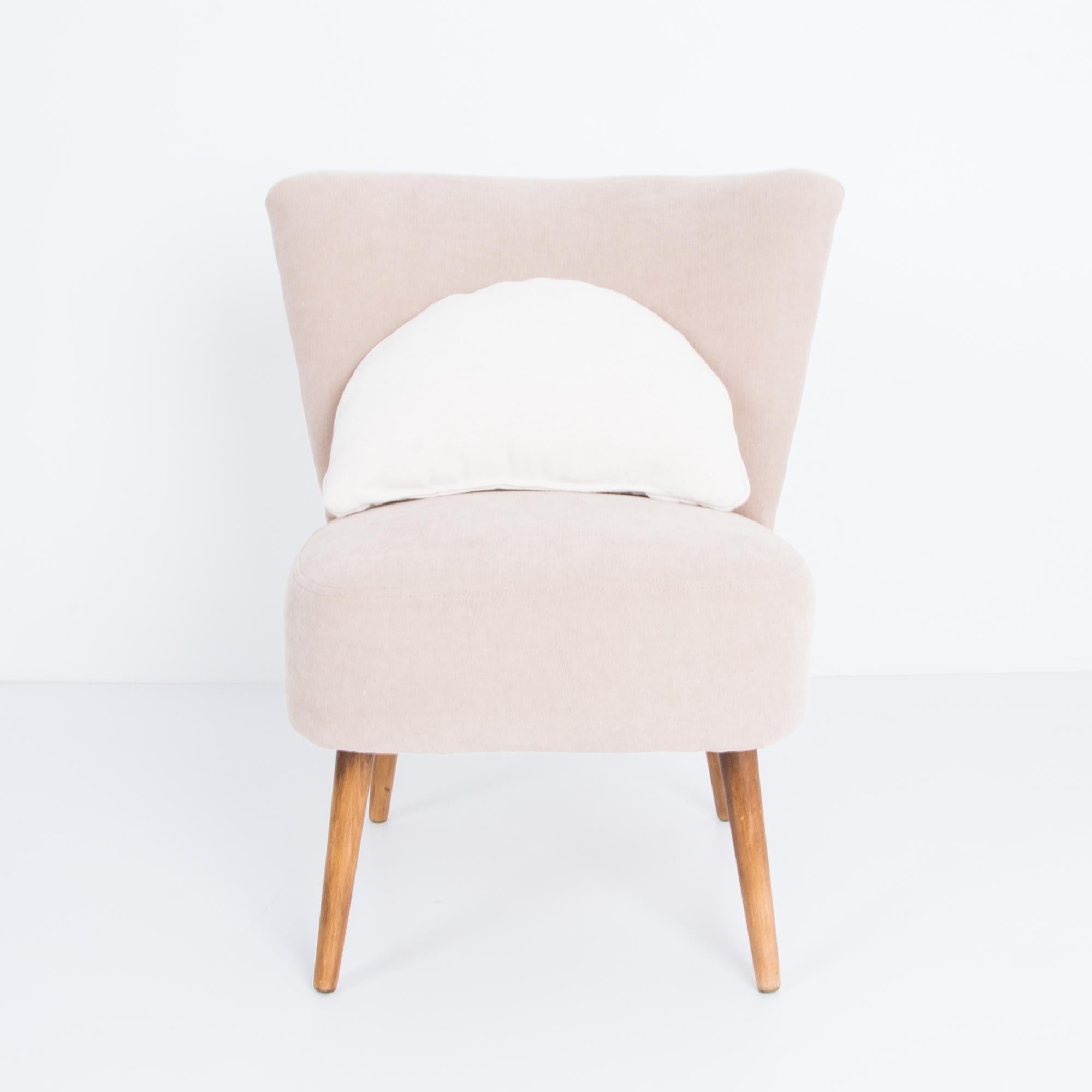 A Mid-Century Modern upholstered side chair from France. This 1960s vintage design has a gentle geometric motif. The chic tapered seat back gives a bold motif, balanced by angled wooden legs. Updated cotton-linen upholstery in a warm rosey hue,