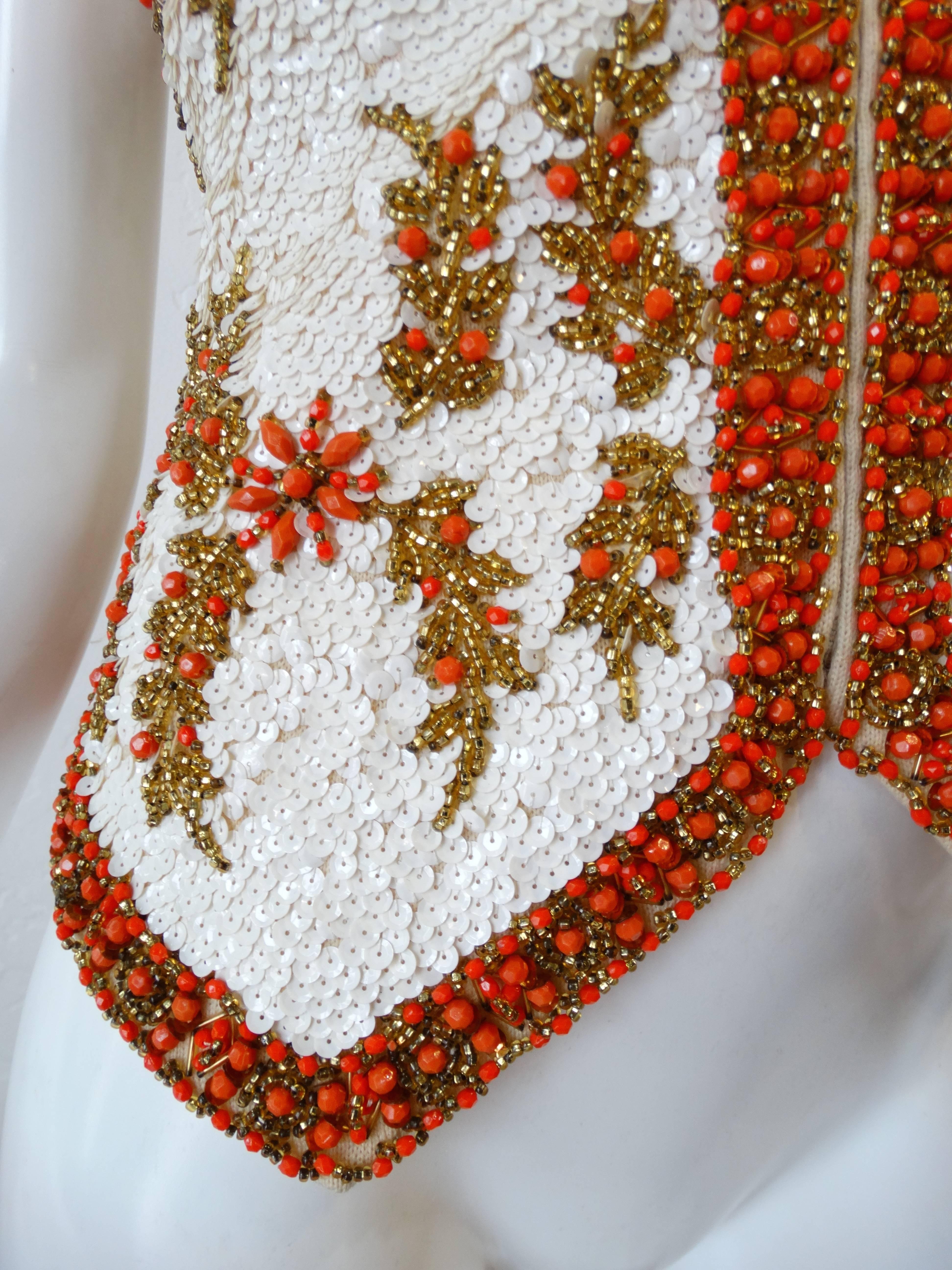 Amazing 1960s sequin zip up vest from Valentina Ltd! Valentina Ltd was a knitwear company circa 1960s known for their intricately embellished pieces. This piece is no exception- covered in pearly white sequins contrasted with gold and bright orange