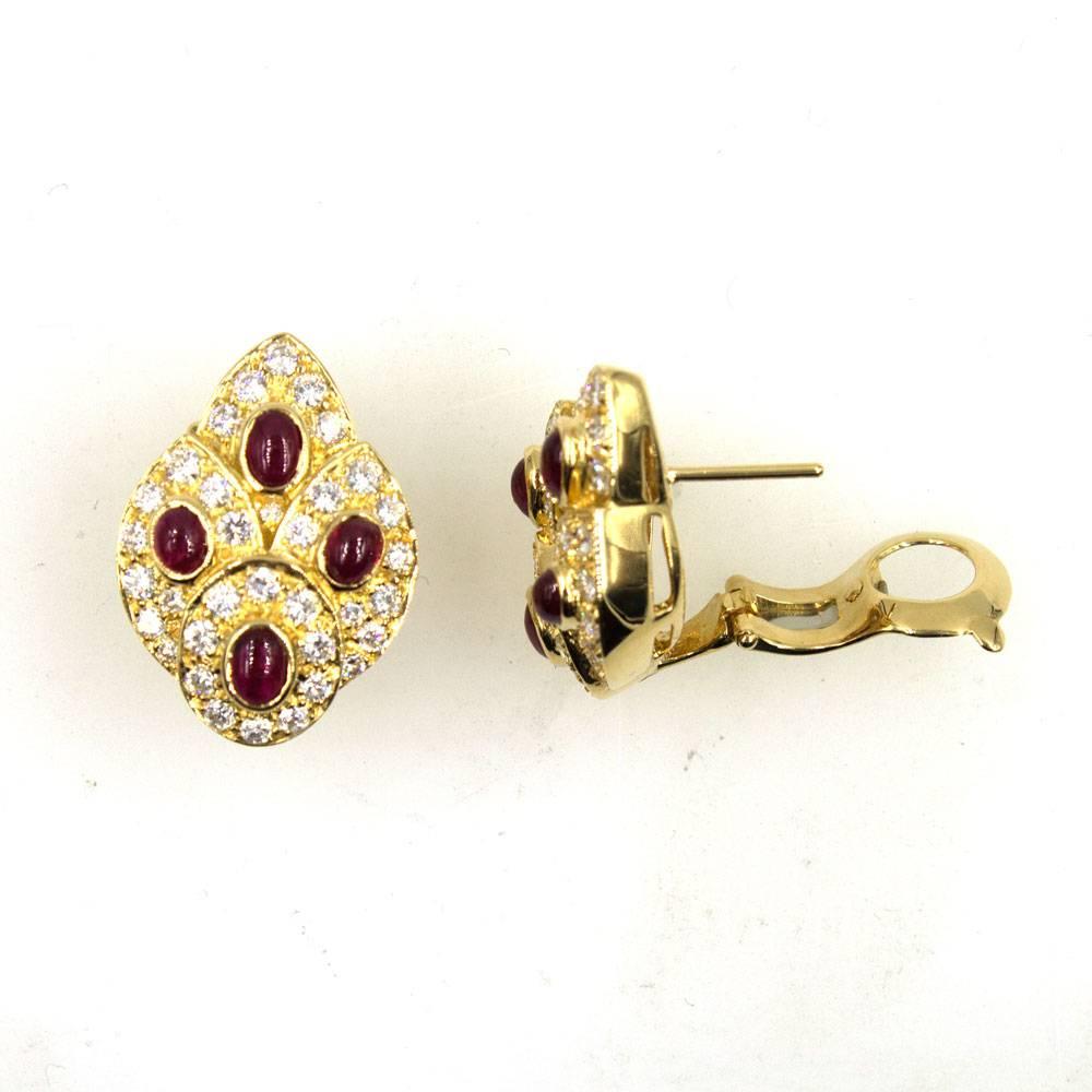 Fabulous and elegant diamond and ruby earrings by Van Cleef & Arpels. The earrings can be worn as clips or with posts (retractable posts). Two carats of sparkling round brilliant cut diamonds surround 8 cabochon bright red rubies. Fashioned in 18