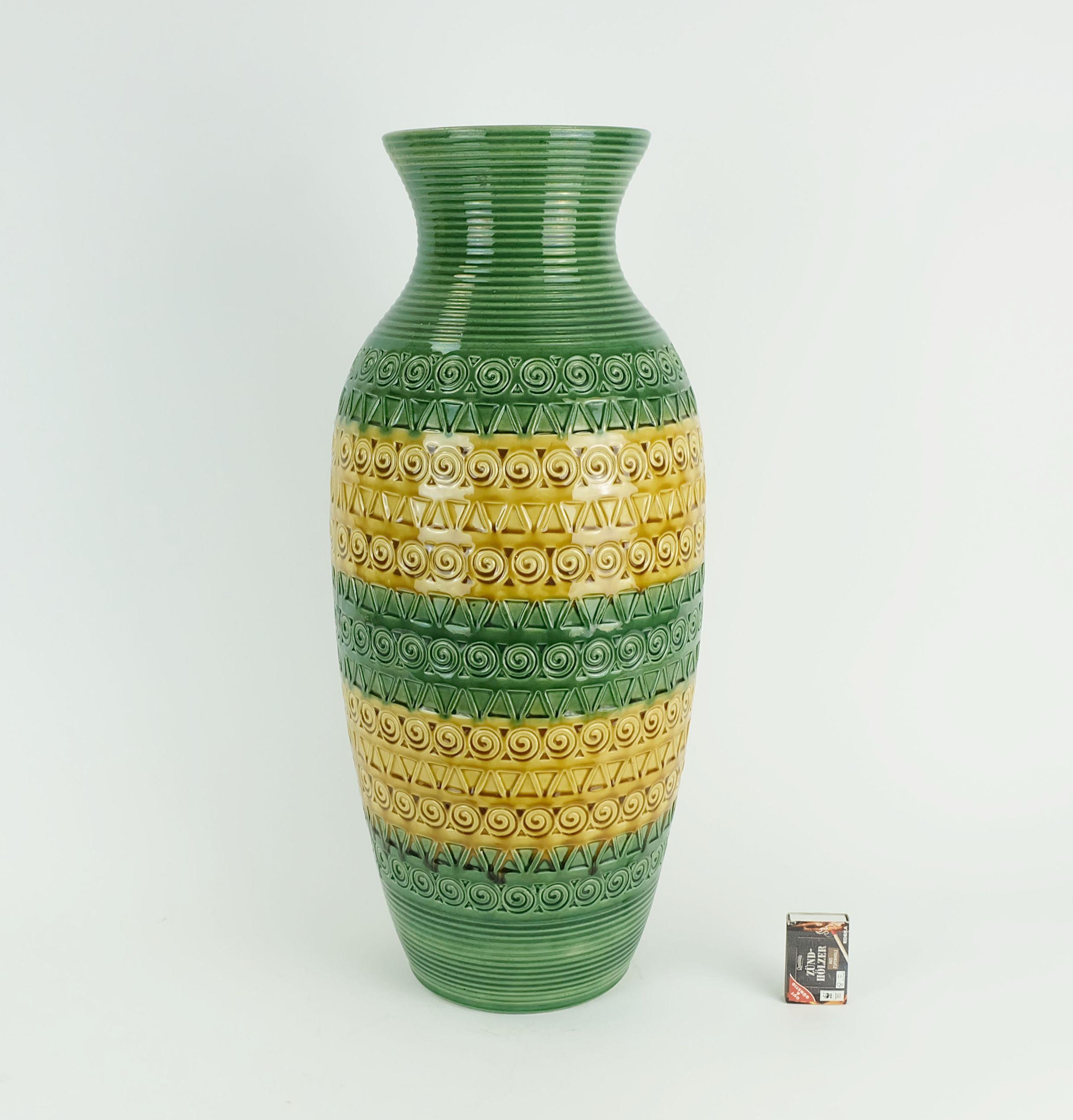 Jarrón de cerámica fabricado por Ü-Keramik West-Germany en la década de 1960. Rayas en bloque en verde y ocre combinadas con un bello dibujo en relieve. Model No. 1142-50. 

Dimensiones en cm: 
Altura 50 cm, anchura 22 cm.

Dimensiones en