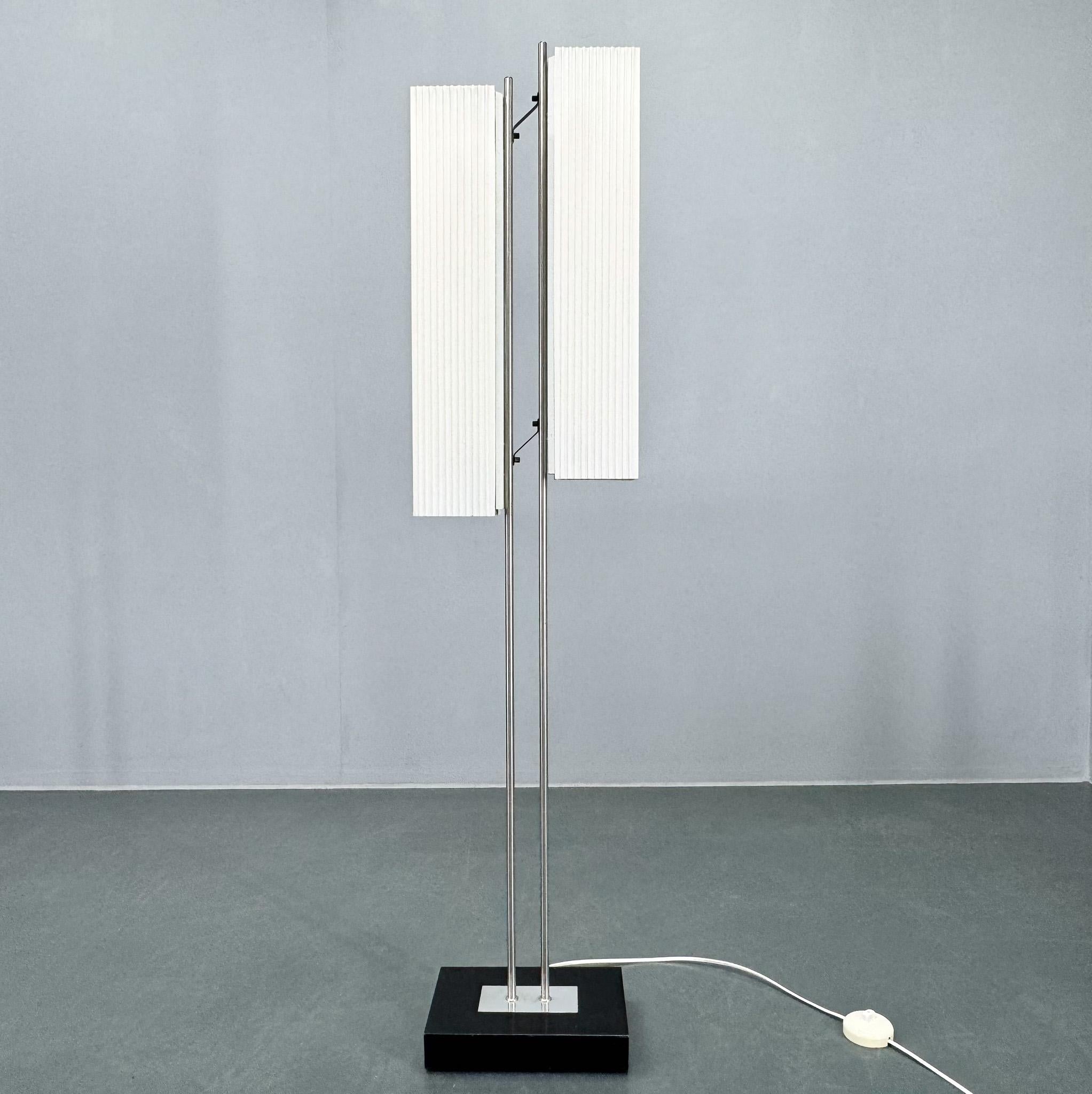 Lampada da terra vintage modello 6067 realizzata da VEB Wohnraumleuchten Berlin nel 1965 circa. Base in ferro annerito, tubo nichelato, paralume pieghevole in plastica simile alla carta bianca. 
2 lampadine a tubo. Cablaggio nuovo, interruttore