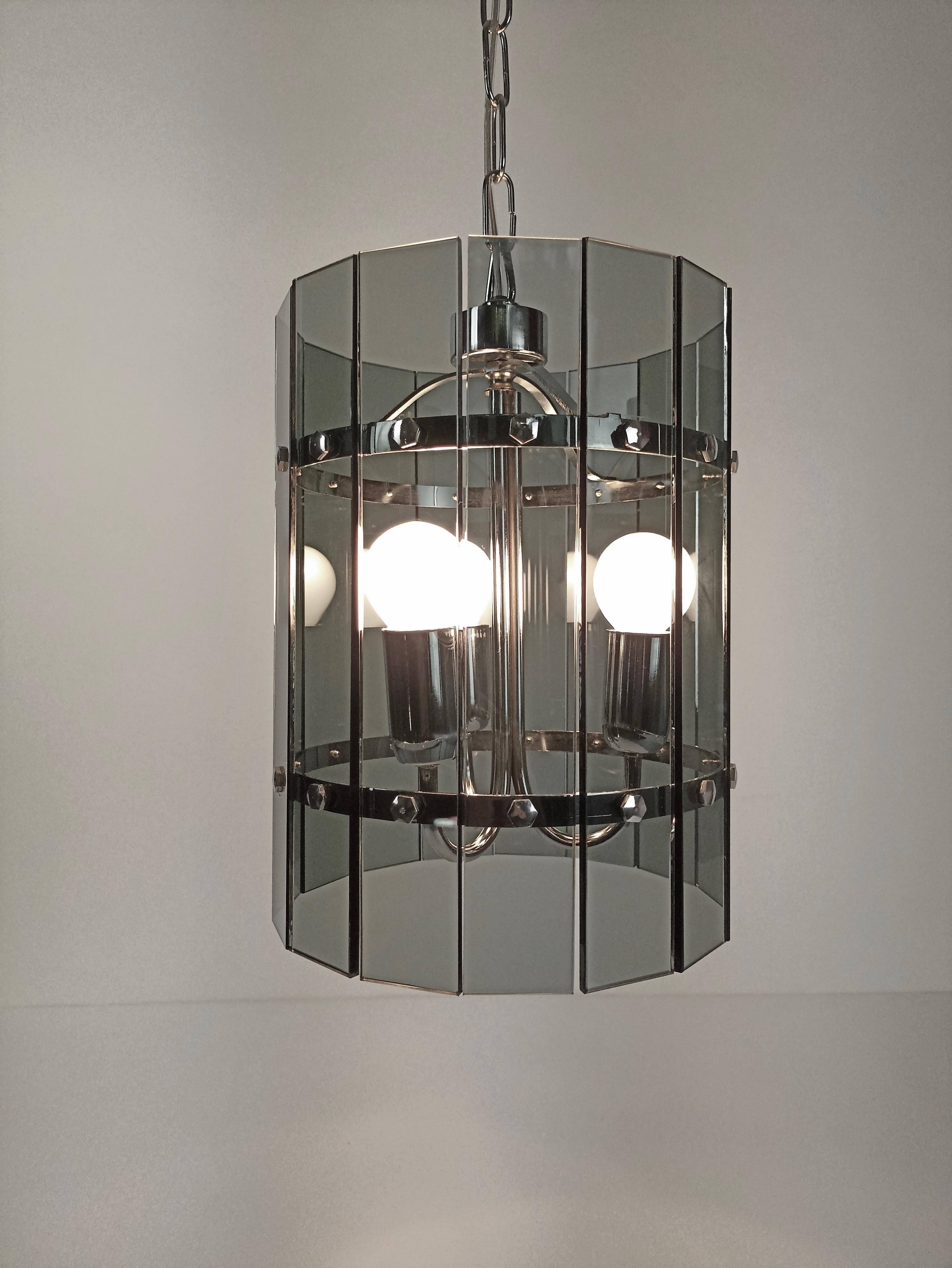 Beautiful vintage three-light ceiling lantern from the late 1960s in the style of Veca.
The frame is made of chrome-plated metal on which are mounted 15 smoky grey crystal plates. 
Dimensions:
total height with chain: 89 cm/ 35.03 in (can be