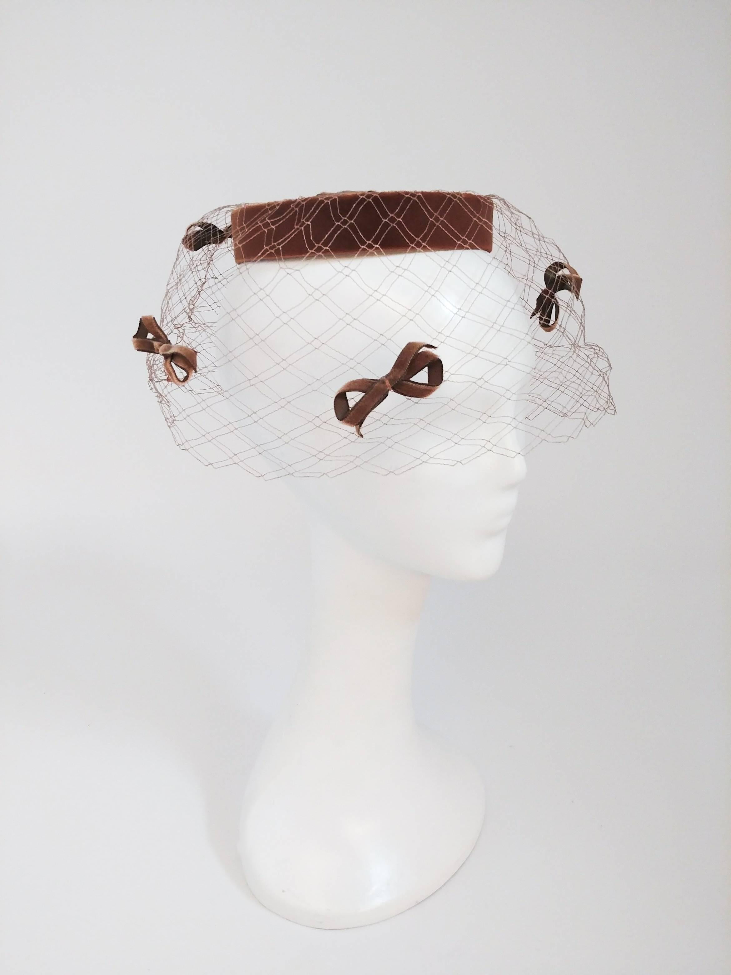 chapeau à anneau en voile de velours des années 1960. Des nœuds décoratifs en velours sur le voile. Le chapeau est placé à l'arrière de la tête.