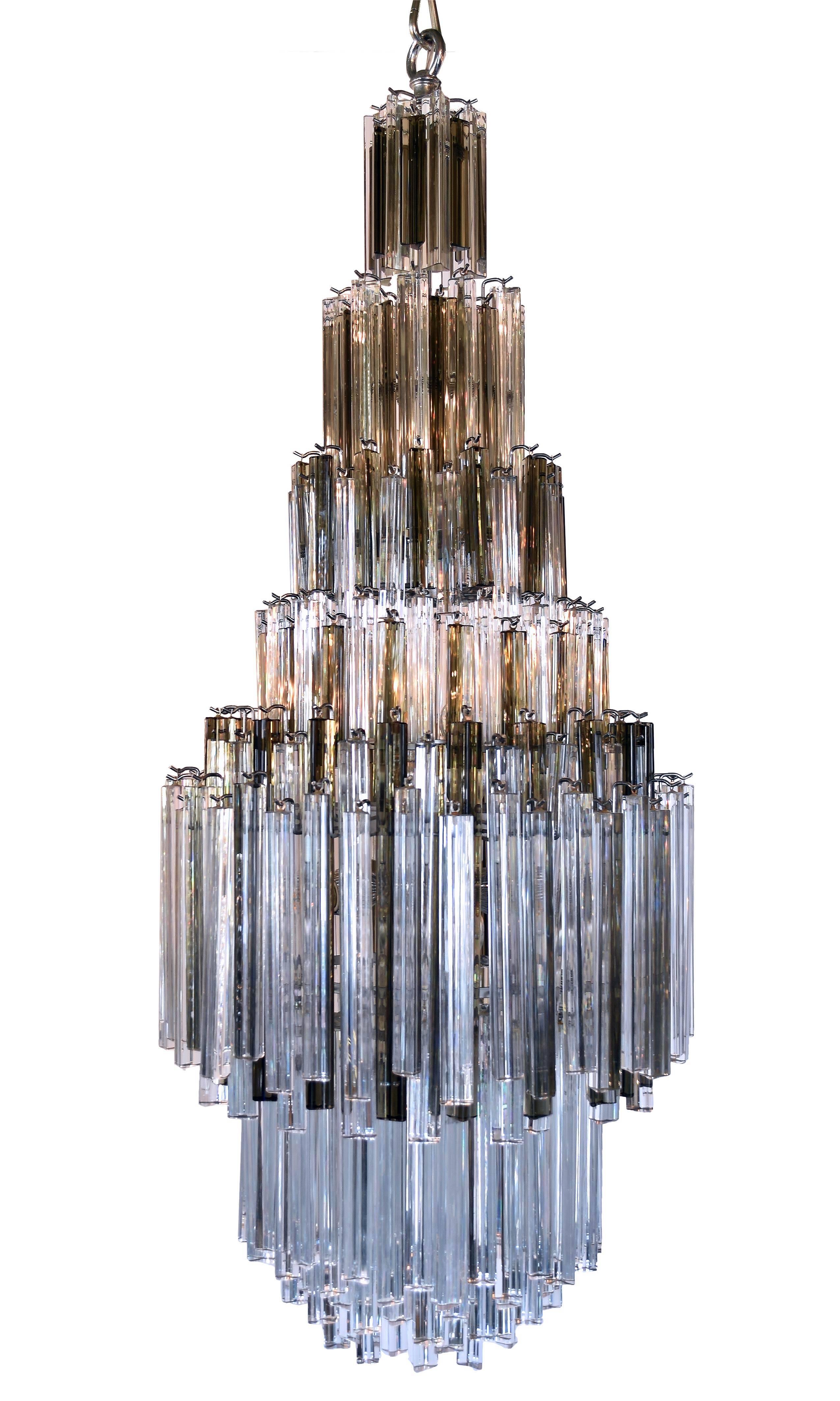 Multiple tiers of Italian Murano Triedri crystals, including both smoked and clear, adorn this chandelier manufactured by Venini of Murano, Italy. This chandelier is perfectly refined to reflect ideas of elegance in conjunction with a style that is
