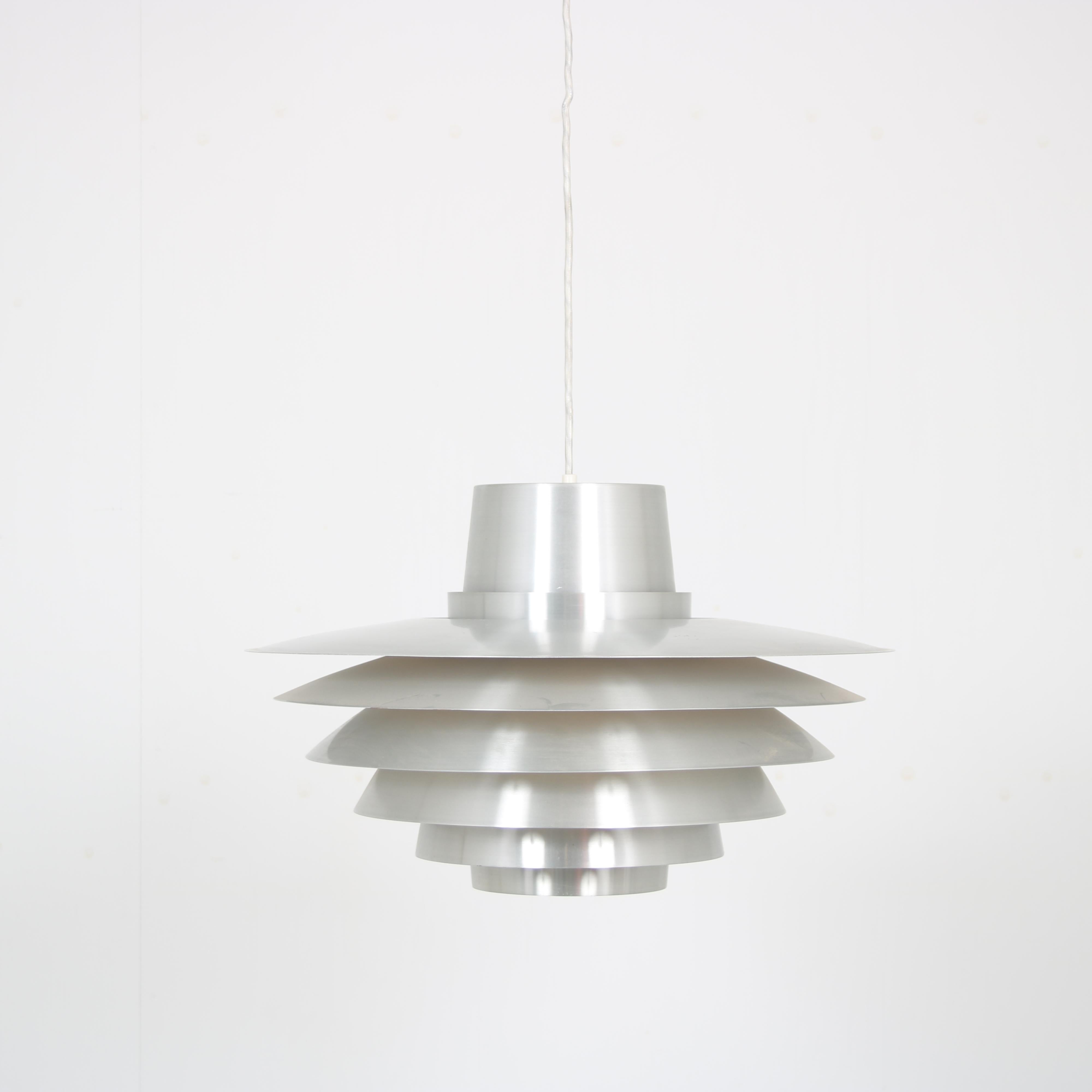 A beautiful hanging lamp, model “Verona”, desined by Svend Middelboe and manufactured by Nordisk Solar in Denmark around 1960.

This modern lamp is made of high quality aluminium in different layers. This allows aunique, beautiful light to emit when