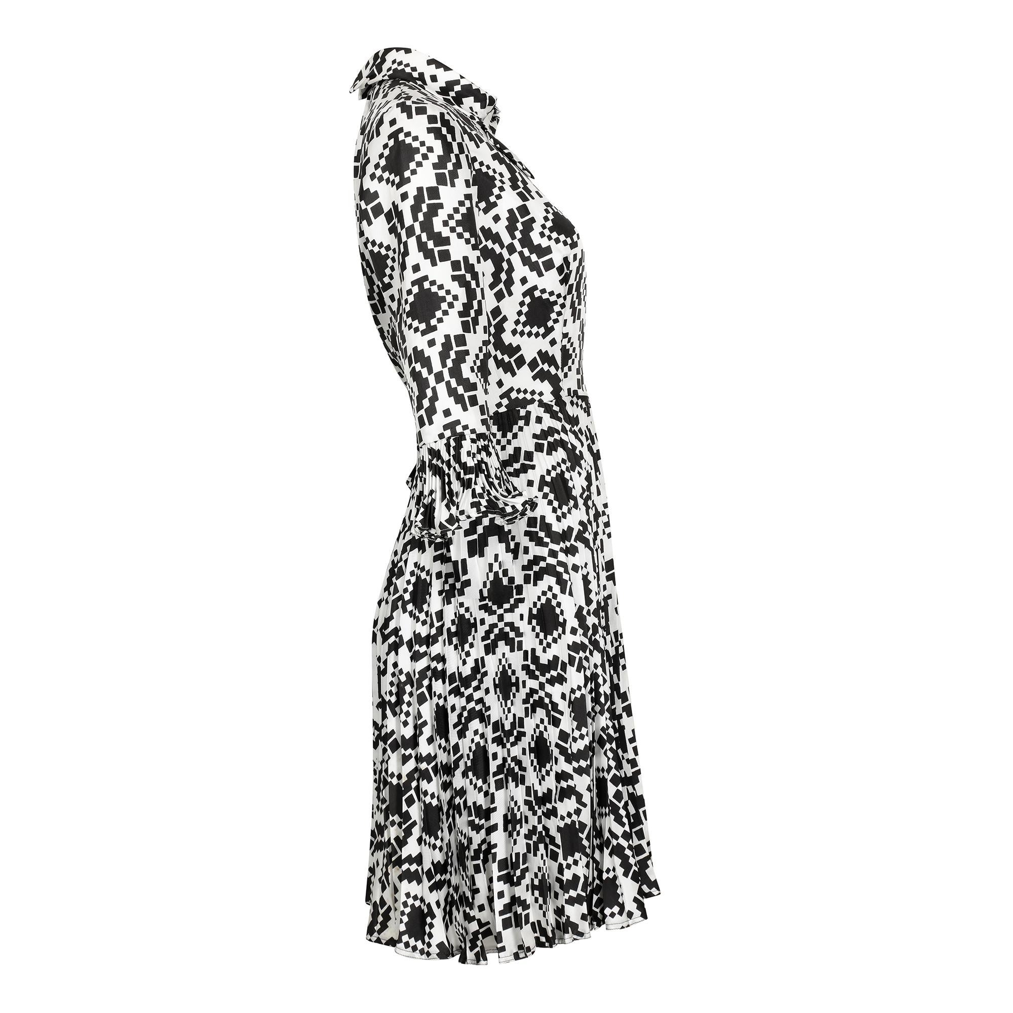 Vestido monocromo de estampado geométrico del diseñador Rembrandt de los años 70. Este diseño clásico tiene bonitos detalles, como los puños plisados estilo poeta y un delicado cuello cruzado. El corpiño tiene pinzas, mientras que la falda tiene