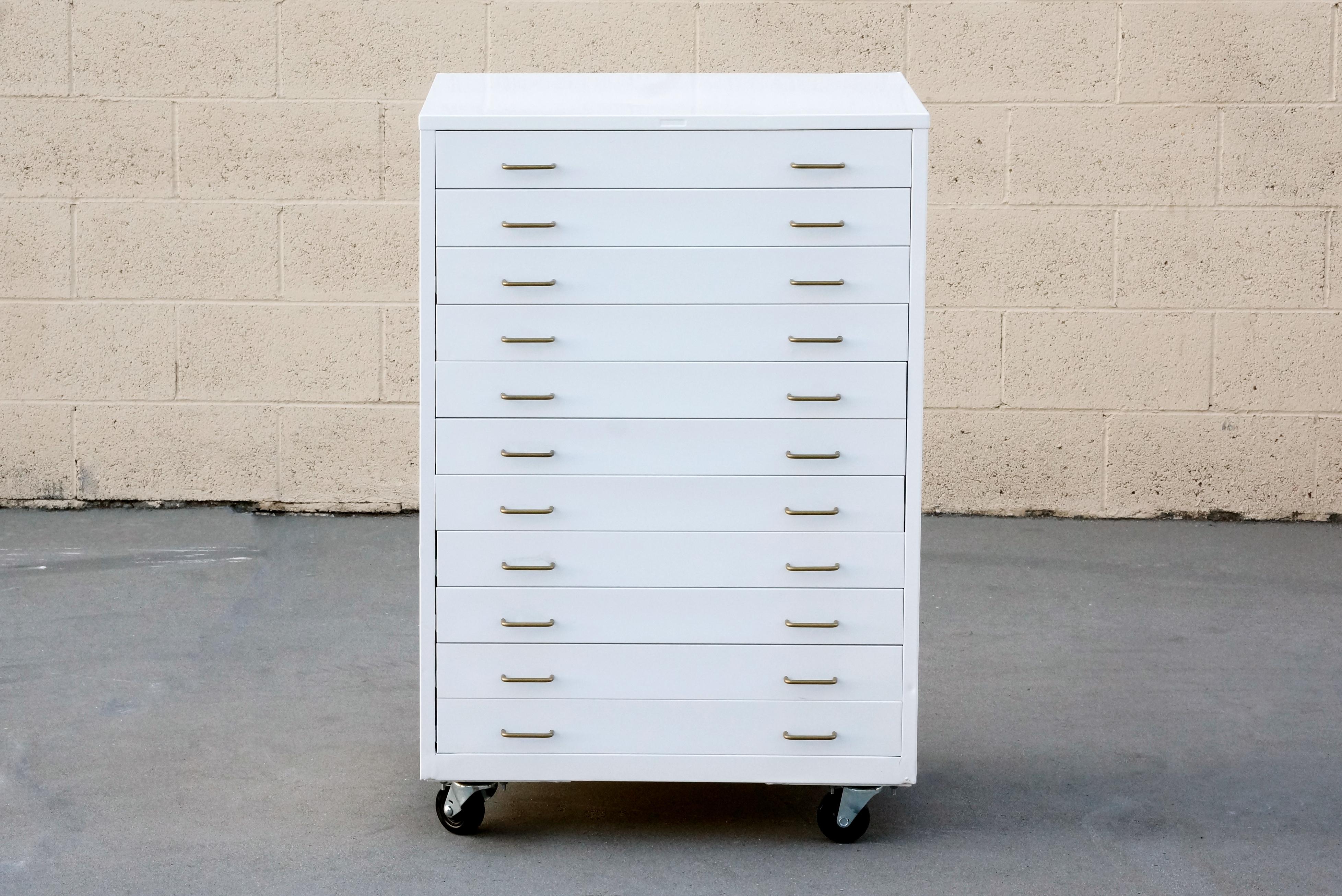 Midcentury flat file in an uncommon vertical configuration. All steel frame newly powder coated in gloss white with metallic gold handles. Features 11 drawers ideal for storing prints, flat art and valuables. 

Overall dimensions: 
20