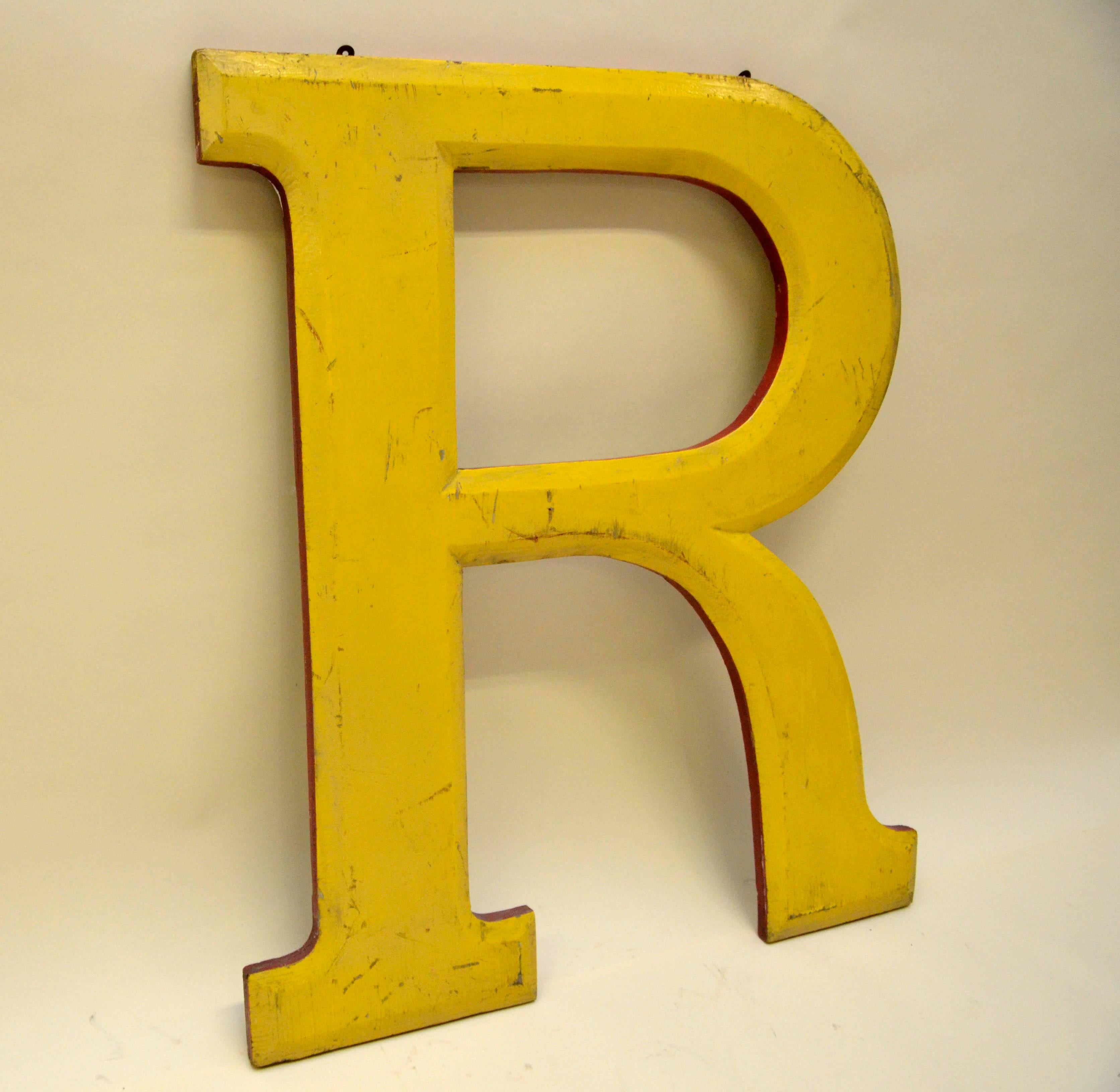 Very large yellow wooden capital letter R with red border made in England probably in the 1960s as part of the sign of a pub.

From the same sign also available in stock letters: T.
