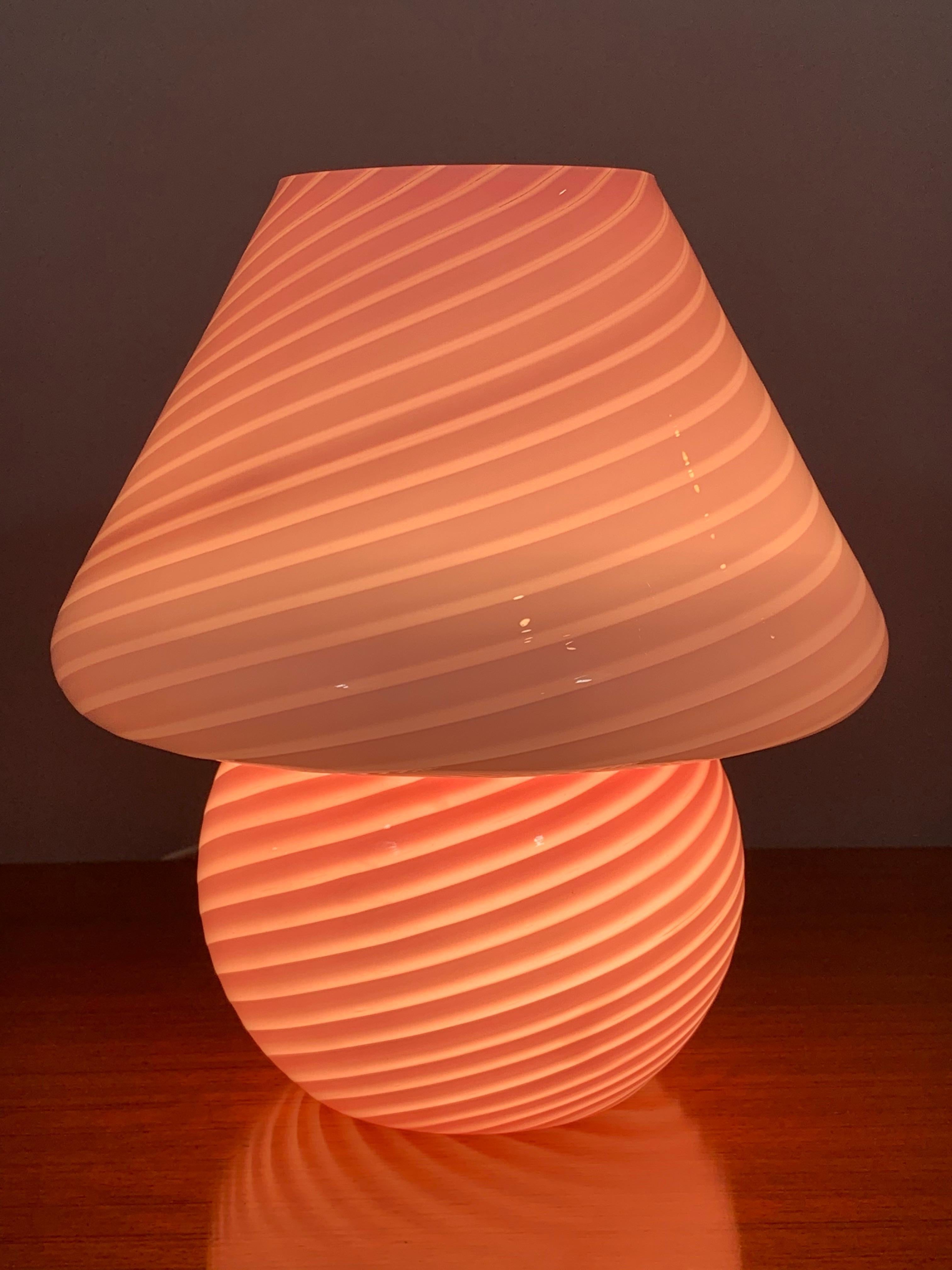 A 1960s Italian table lamp by Vetri d‘Arte Murano. The lamp is made from one piece of hand blown pink glass in an unusual mushroom shape with a white swirled design around its entire surface. In very good vintage condition. Part of the original