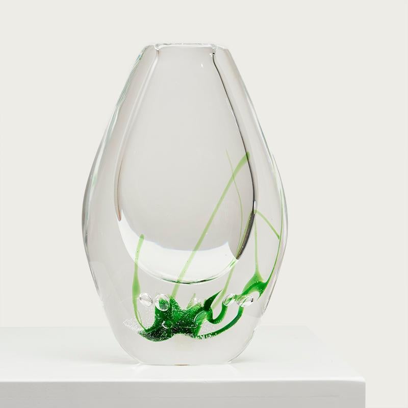 Vase en verre transparent ''Seagrass'' de Vicke Lindstrand pour Kosta Boda. Suède, années 1960.

Ces vases en verre sont gracieusement décorés avec la technique Ariel que Vicke Lindstrand a inventée avec Edvin Öhrström et Knut