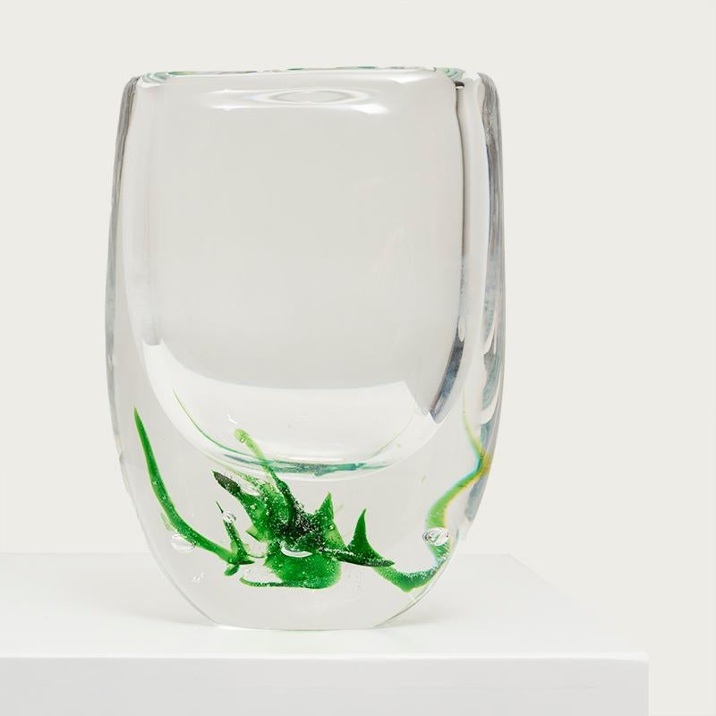 Vase aus Klarglas ''Seagrass'' von Vicke Lindstrand für Kosta Boda. Schweden, 1960er Jahre.

Diese Glasvasen sind mit der Ariel-Technik verziert, die Vicke Lindstrand zusammen mit Edvin Öhrström und Knut Bergqvis erfunden hat.

Lindstrand war