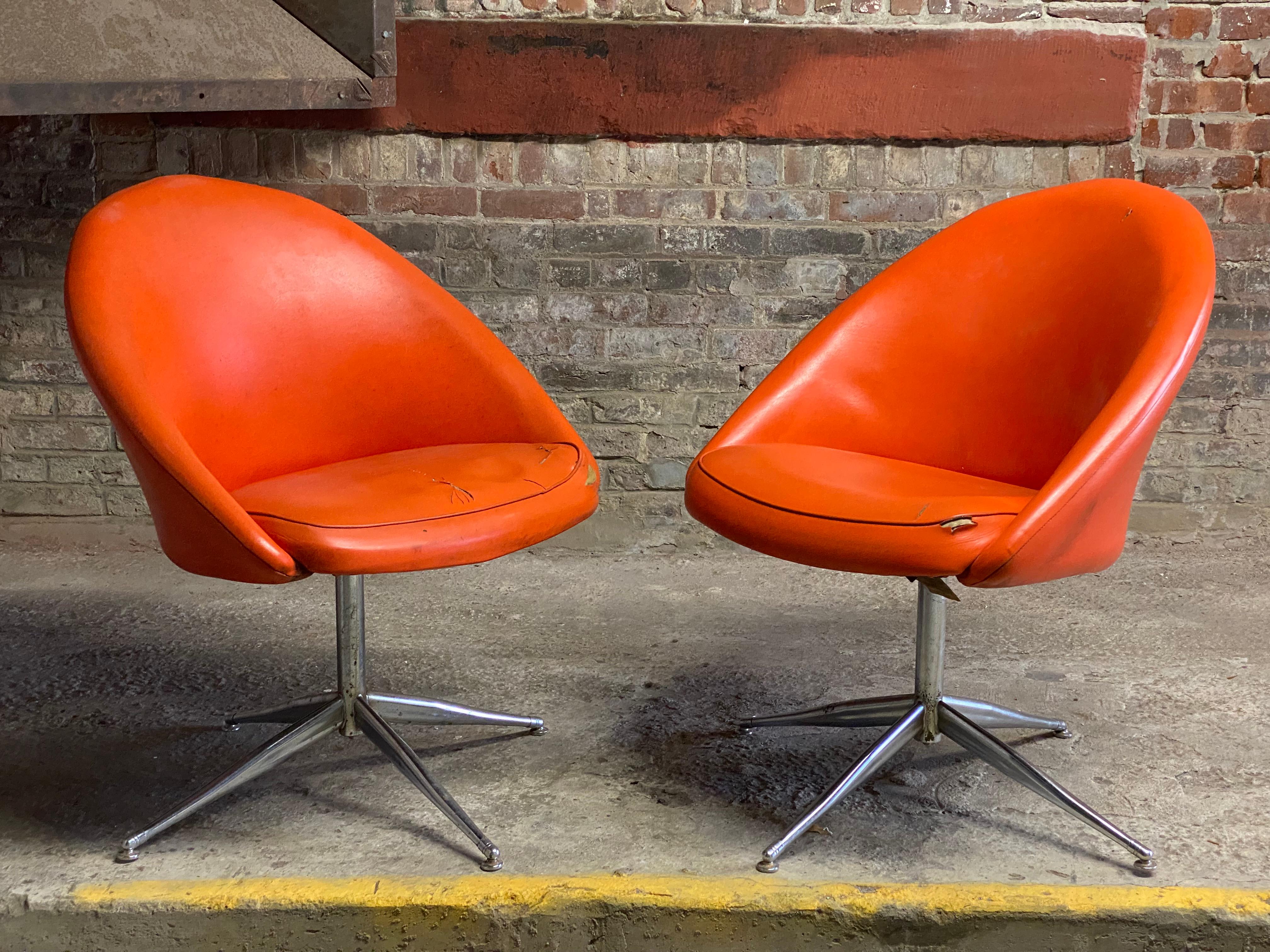 A good pair of Baumritter swivel chairs in orange naugahyde and chrome star bases. Circa 1960-70. Both examples have the Viko by Baumritter signature and model number, 836202. Structurally sound and sturdy construction. They swivel with ease and do