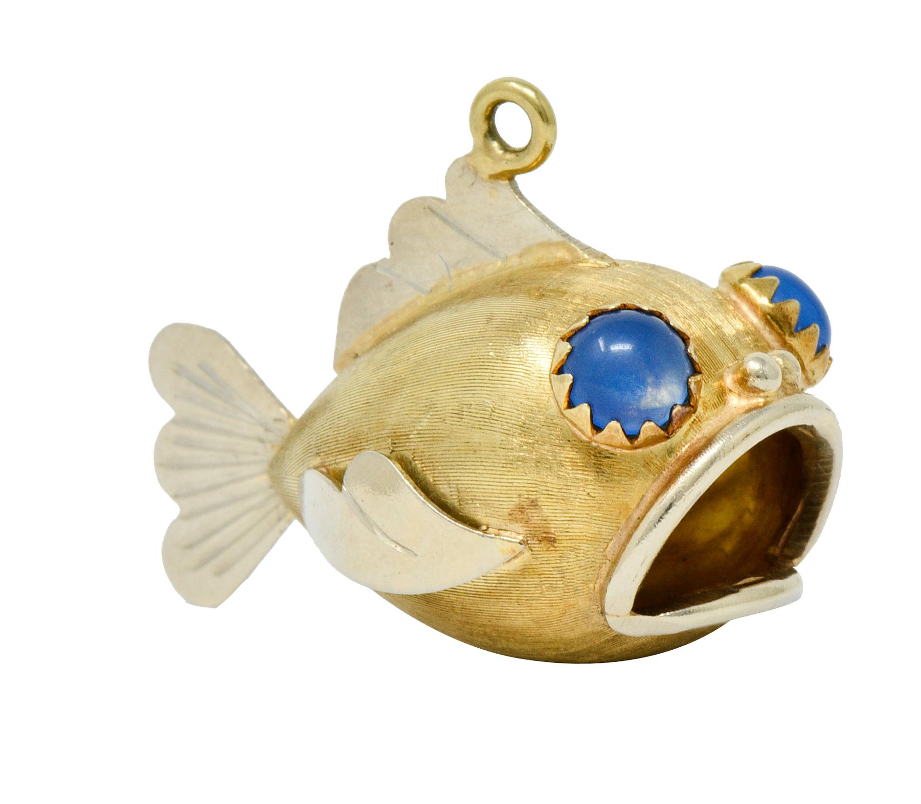 Fish charm is designed with an open mouth revealing the open cavity of its stomach

With cartoonish white gold features and a strongly brushed yellow gold body

Featuring 5.0 mm round glass cabochon eyes; bright translucent blue in color

Tested as