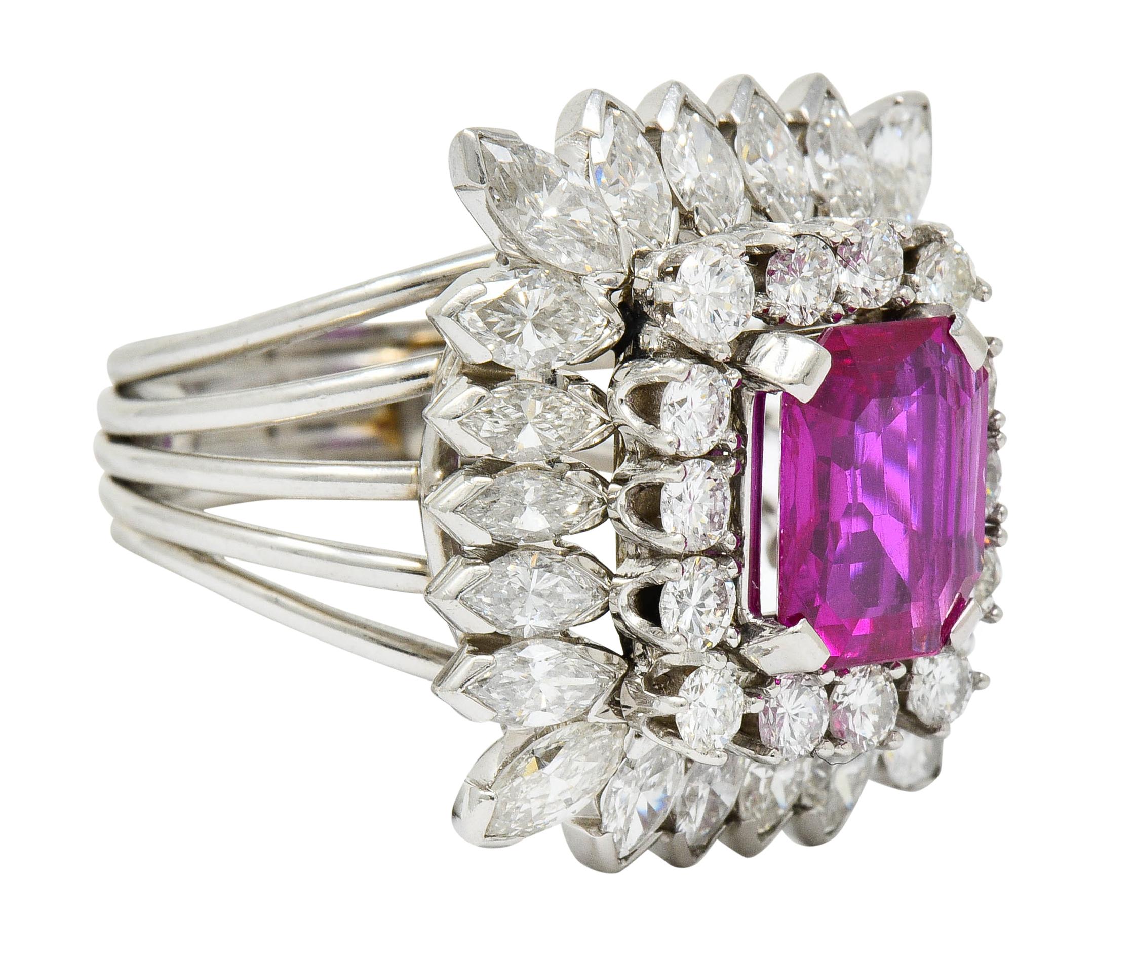 Cluster style ring centering an emerald cut Burma ruby weighing approximately 2.20 carats

Transparent and bright pinkish-red in color with no indications of heat

Surrounded by two tiers of round brilliant and marquis cut diamonds weighing in total
