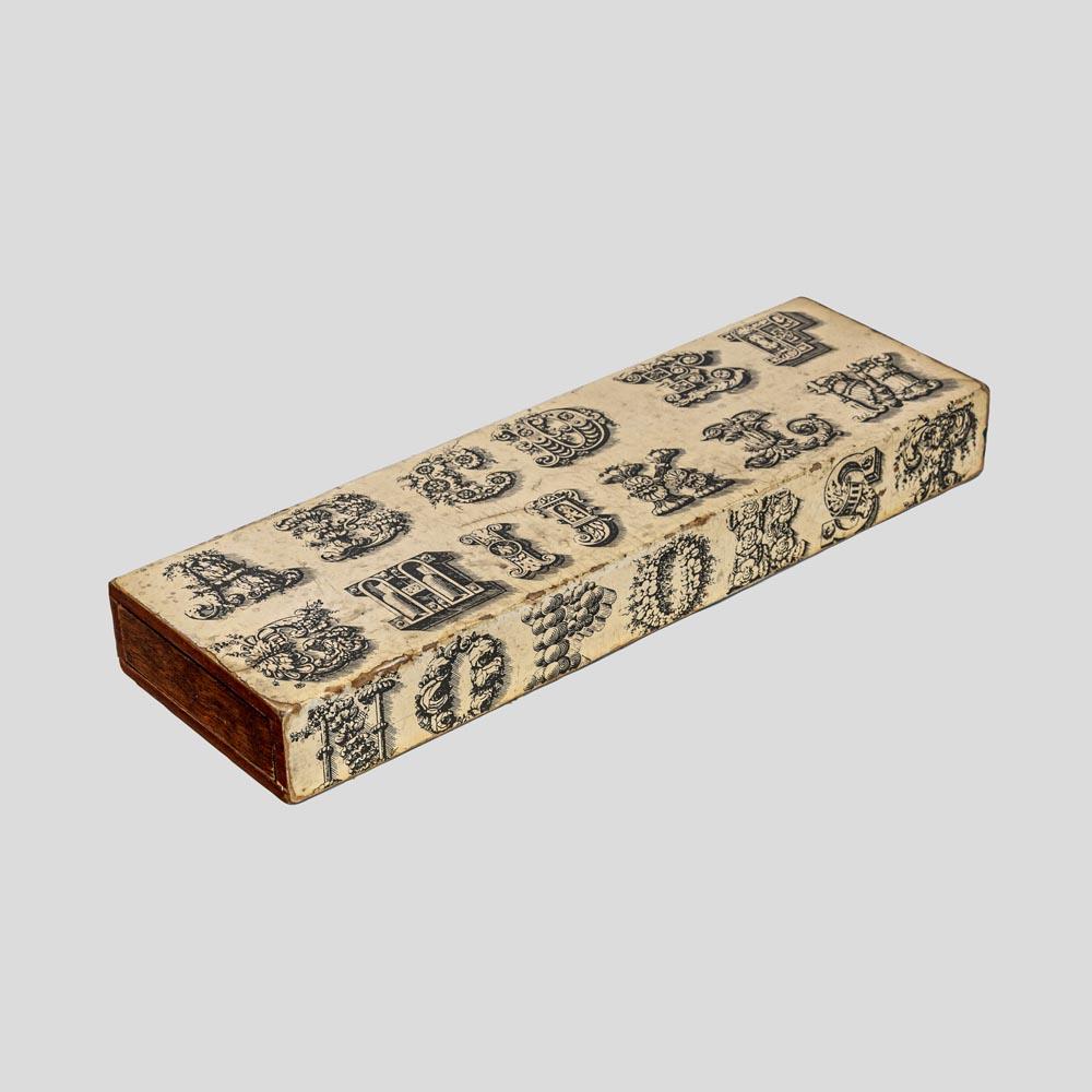 A very elegant rectangular ”Alphabet” box designed by Piero Fornasetti in the 1960s. Wooden structure cream enamelled top and sides decorated with letters of the alphabet in an ancient baroque style transferred with a printing process.
This box is